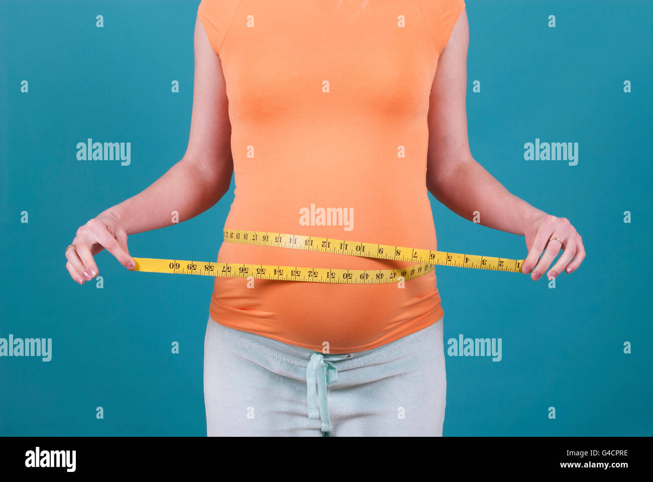 Pregnant woman measuring belly with tape measure Stock Photo Alamy