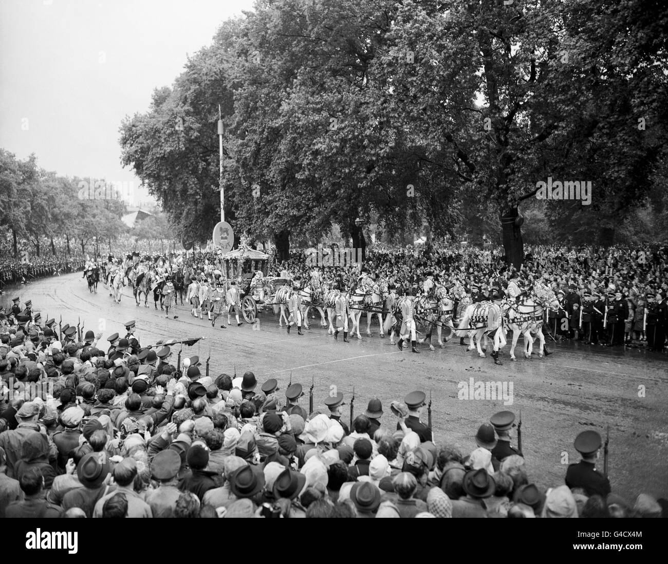The golden State Coach bearing Queen Elizabeth II and the Duke of Edinburgh passes through the East carriage Drive in Hyde Park on the return from Westminster Abbey to Buckingham Palace after the Coronation. Stock Photo