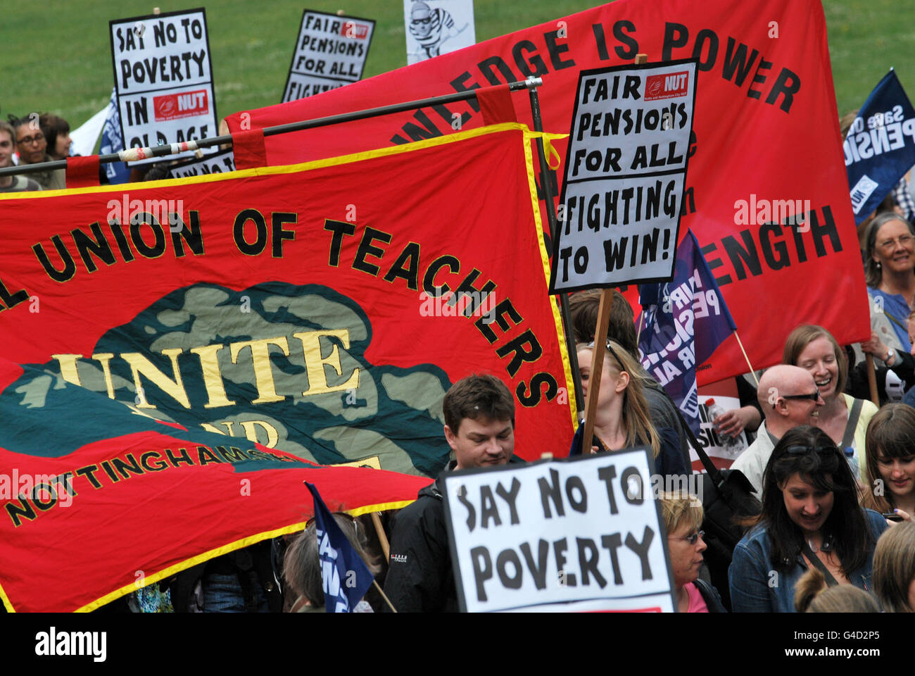 Protesters hold placards in Nottingham city centre during a one day national strike against pension changes and funding cuts to the public sector. Stock Photo