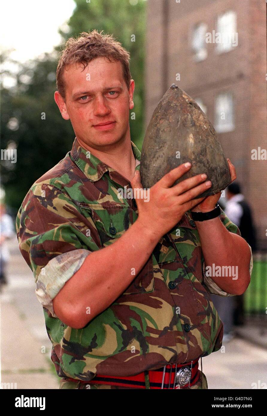 Captain Sean Matten, of the 33 Engineer Regiment (Explosives), holds the nose of a World War II bomb, which was discovered yesterday by workers on a building site in Harford Street, Stepney, east London. Nearly 2,000 residents were evacuated from the area while Capt Matten defused the bomb. See PA story DEFENCE Bomb. Photo by Fiona Hanson/PA Stock Photo
