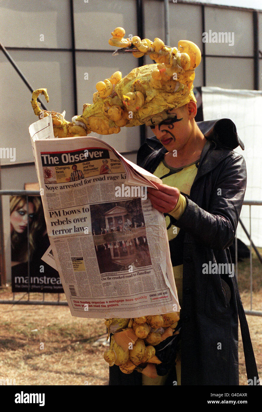 PA NEWS PHOTO 30/08/98 A BIZARRELY-DRESSED FESTIVAL-GOER CATCHES UP WITH THE NEWS AT READING. Stock Photo