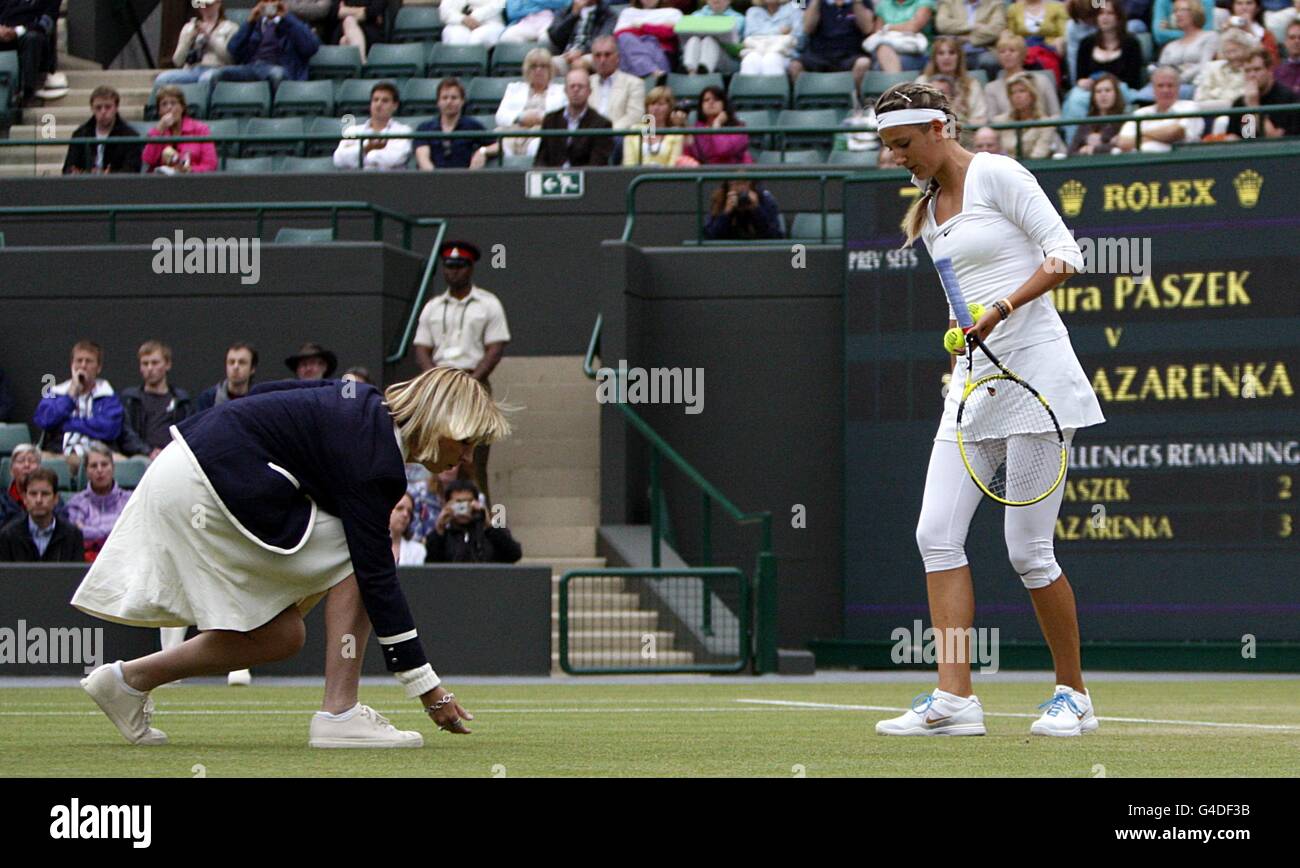 Tennis - 2011 Wimbledon Championships - Day Eight - The All England Lawn Tennis and Croquet Club. Belarus's Victoria Azarenka looks on as the umpire checks the moisture level of the grass as rain stops play Stock Photo