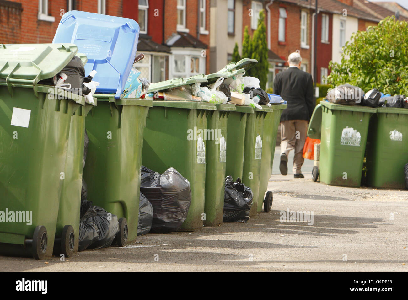 A man walks past overflowing wheelie bins in Southampton where