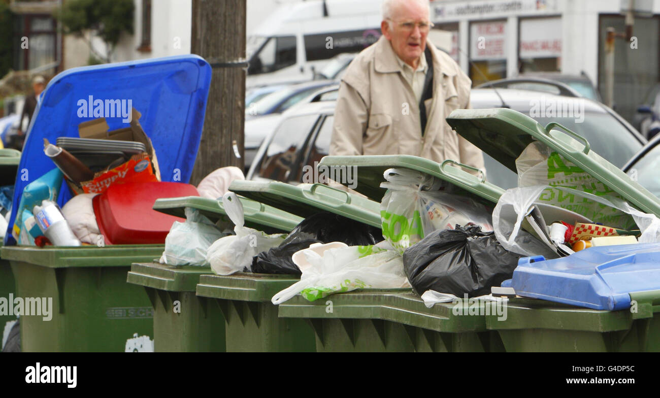 A man walks past overflowing wheelie bins in Southampton where