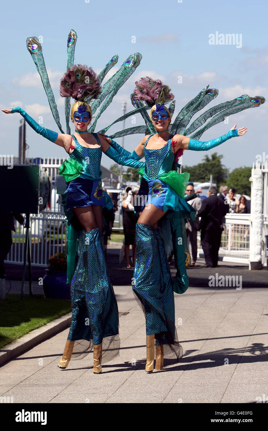 Girls on stilts walk around during Ladies Day at the Investec Derby