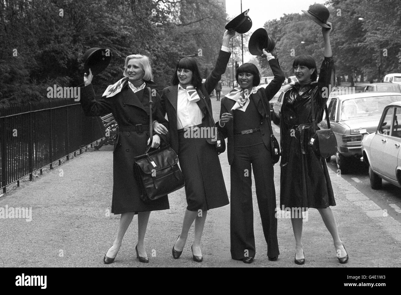 British Airways girls (l-r) Myrtle Winston, Diane Edmunds, Anna Pugin and Chris Harris displaying some of the items from a new wardrobe designed by Baccarat, the British fashion house, for ground and air girls worldwide. The wardrobe includes elegant dark blue pinstripe suits, a belted trench coat, silk scarves bearing the British Airways symbol, and a stowaway raincoat with detachable hood. The uniform is enhanced by a small brimmed hat. Stock Photo