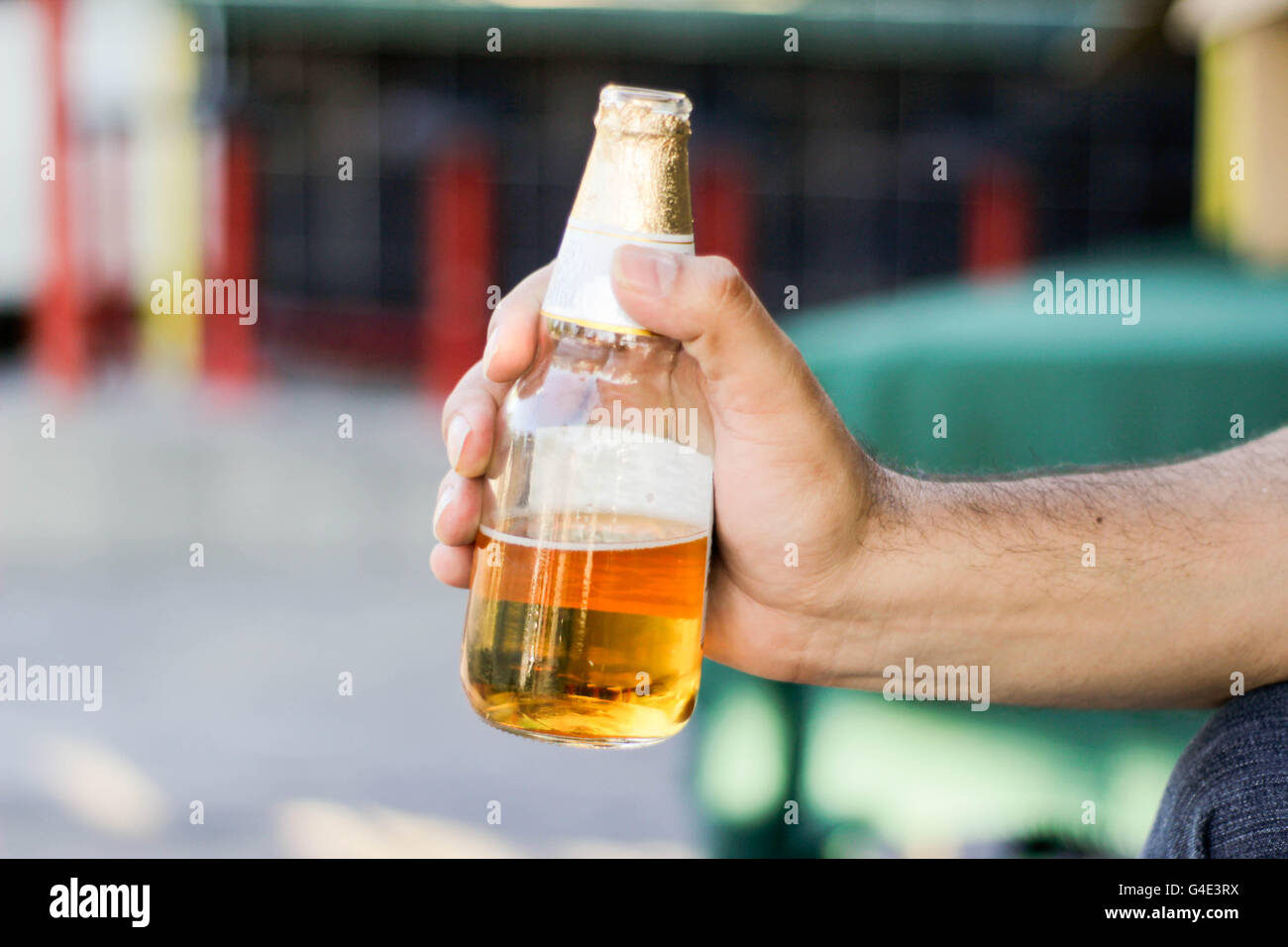 Photograph of a hand holding a beer bottle Stock Photo