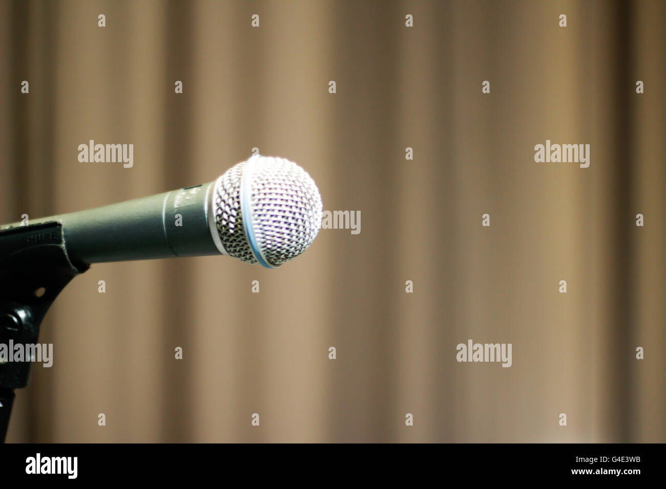 Photograph of a microphone and a blurred theater curtain Stock Photo