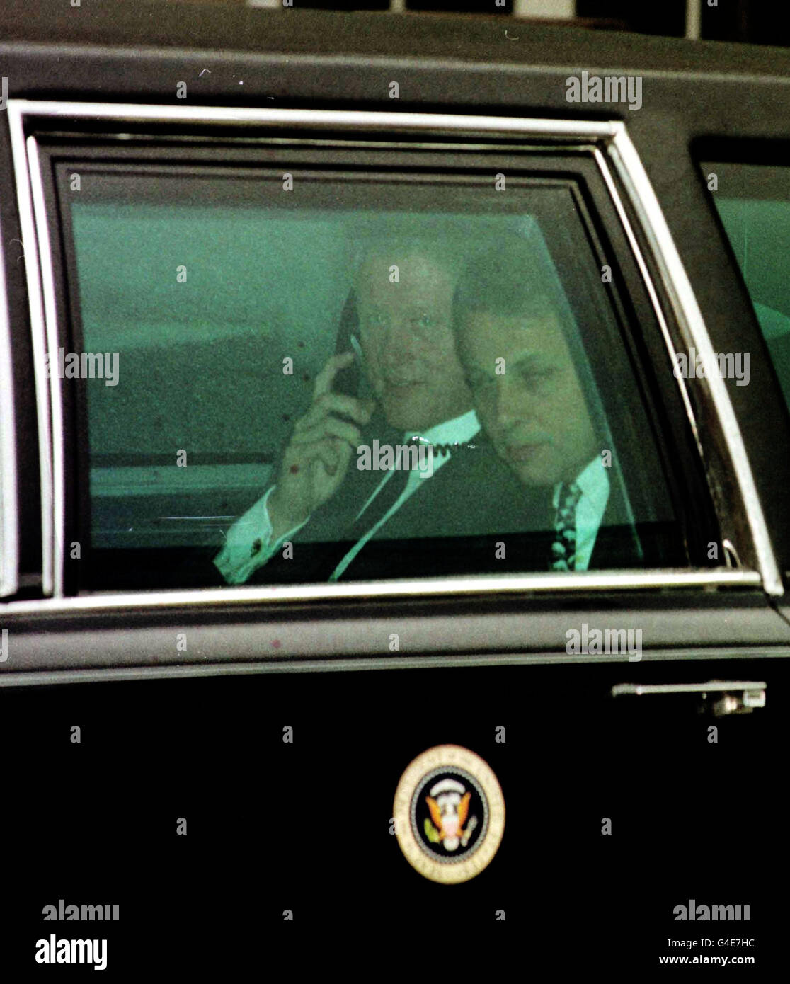 US President Bill Clinton, talks on the phone in the back of the