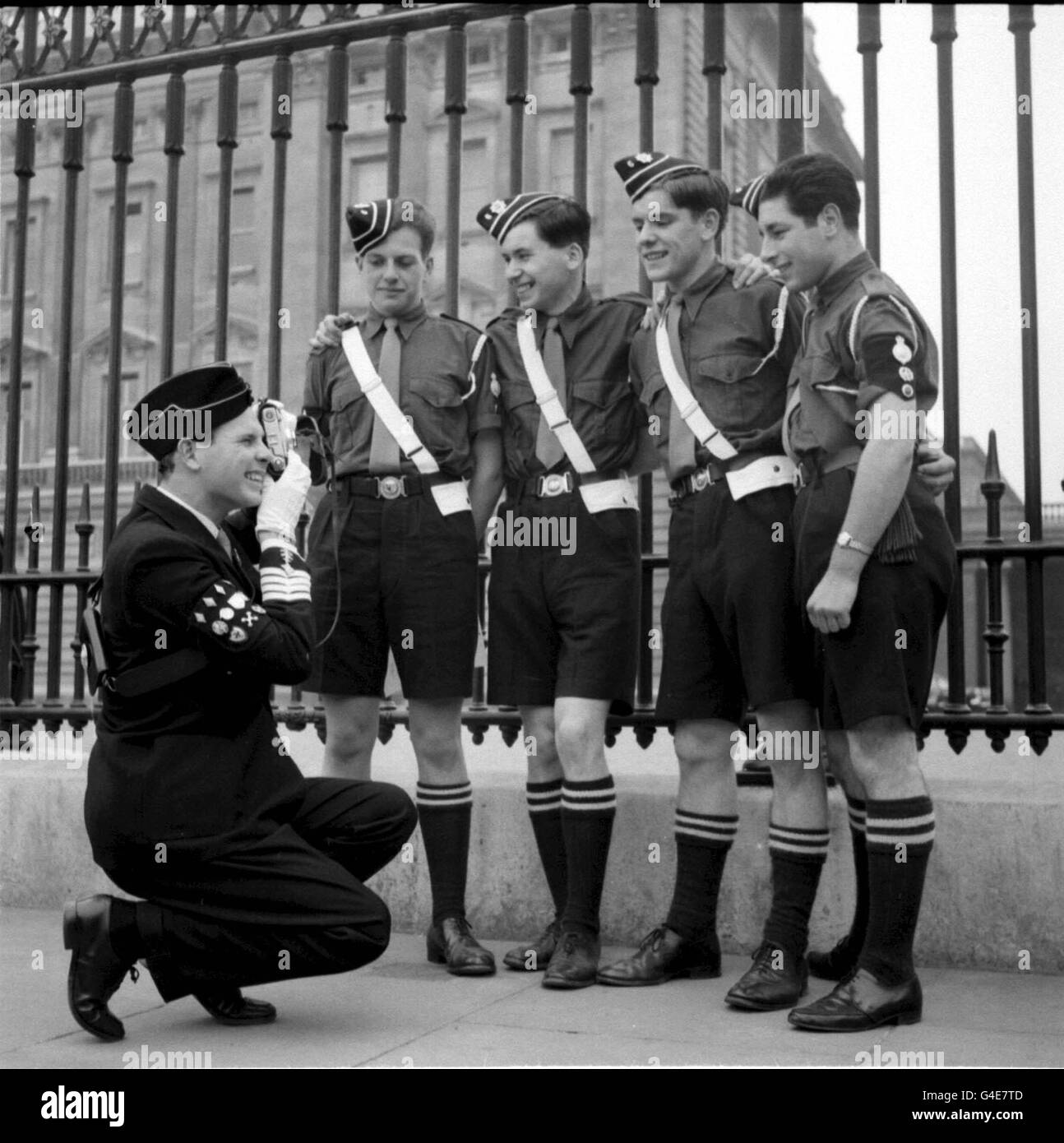 Library filer 83540-1 dated 18.5.60 of Boys Brigade Staff Sergeant Lyle Ellard, putting his camera to good use as he photographs (from left) David Fisher, Len Alcock, Neil Brown and Geoffrey Taylor, outside Buckingham Palace. At the Boys Brigade Annual Conference meeting in south London today (Saturday) members voted against allowing girls into the Brigade. Modernisers within the 115-year-old Brigade were left dismayed after proxy votes from officials across the country were used to defeat the motion on admitting girls by 406-284. PA Photo. See PA story SOCIAL Brigade Stock Photo