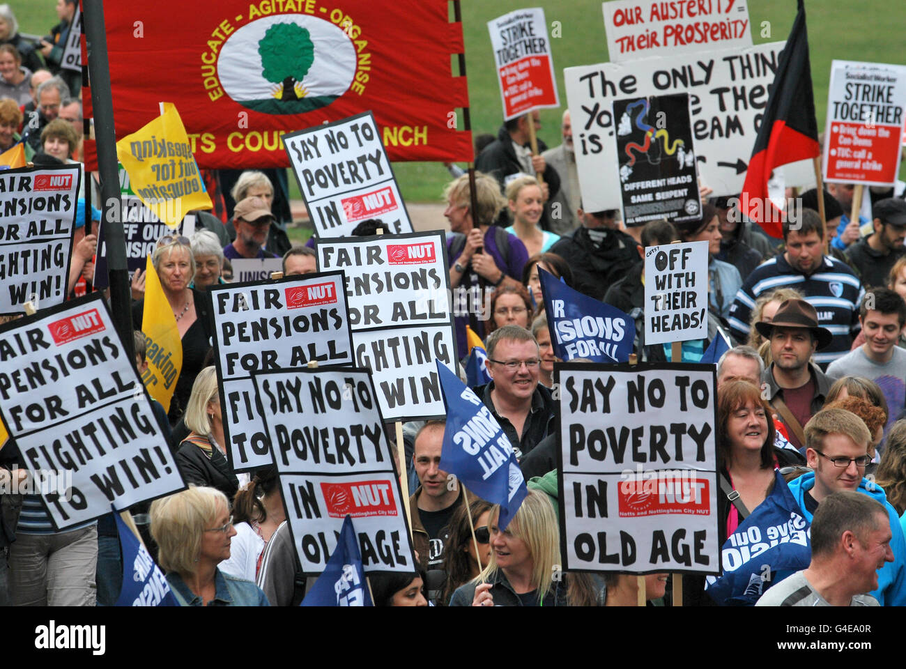 Protesters hold placards in Nottingham city centre during a one day national strike against pension changes and funding cuts to the public sector. Stock Photo