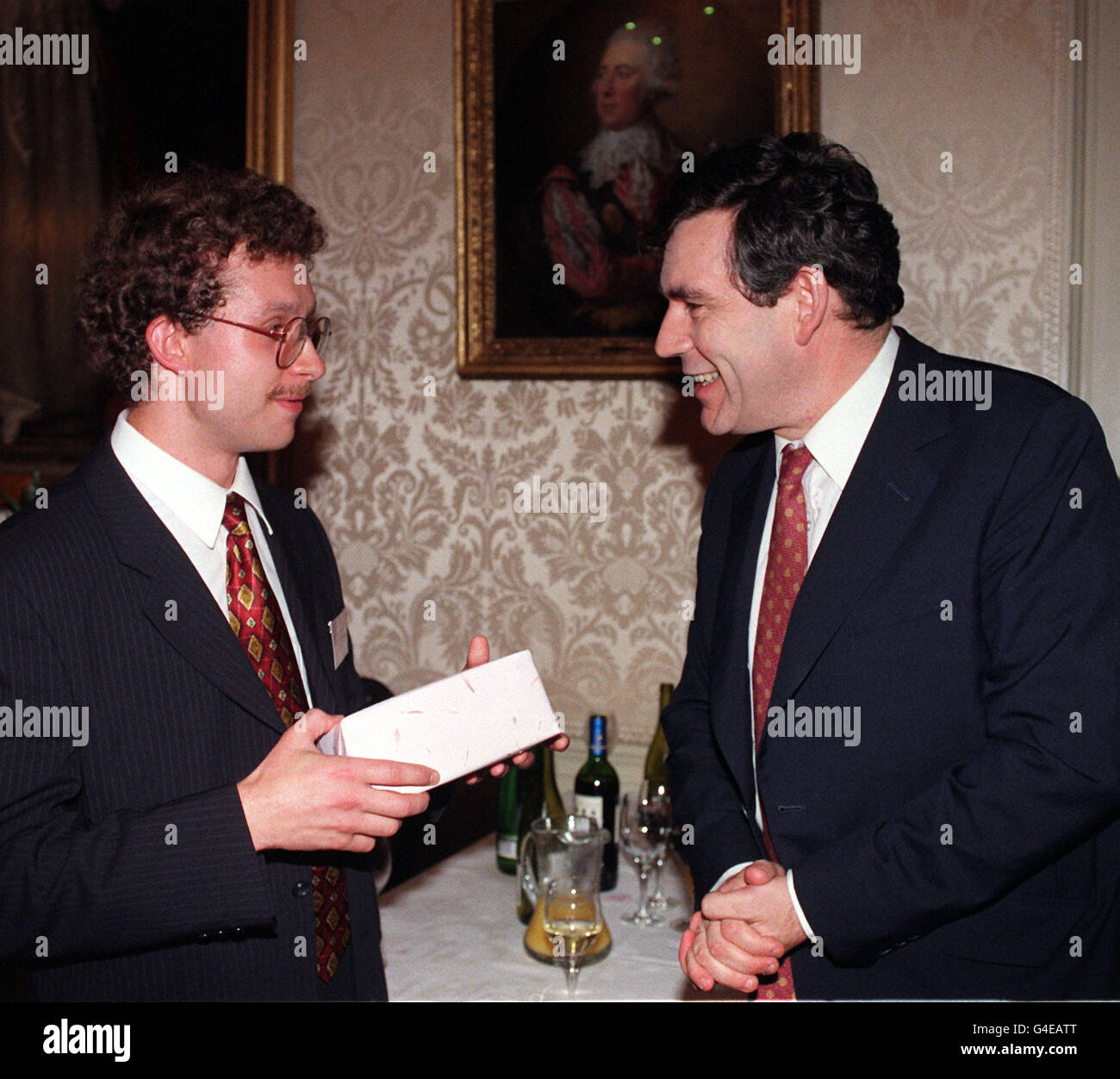 British Chancellor Gordon Brown (right) presents Alexander Antipov, aged 25 from Moscow, the 1000th participant of the Chancellor's Financial Sector Scheme with a gift at No.11 Downing Street this evening (Monday). The Scheme, which since 1992 has offered work placements to young high-flyers from Russia and the other 14 successor states to the Soviet Union. Mr Antipov has been placed with Scudders Investment UK to research international bond markets. Photo by Sean Dempsey/PA. (PA Pool lphoto) Stock Photo