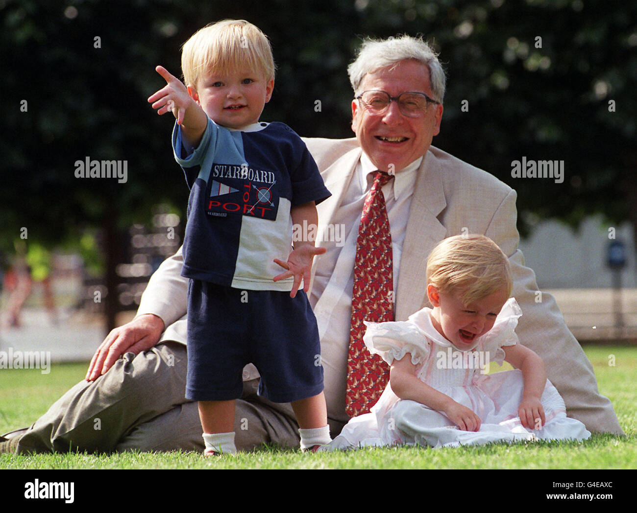 Prof Robert Edwards, one of the pioneering scientists responsuble for IVF (Test Tube) babies on the treatments 20th birthday. Prof Edwards is pictured with two-year-old twins Jack and Sophie Emery whose births resulted from IVF treatment on the lawn of New Palace Yard Westminster today (Monday). Photo by Stefan Rousseau/PA. Stock Photo