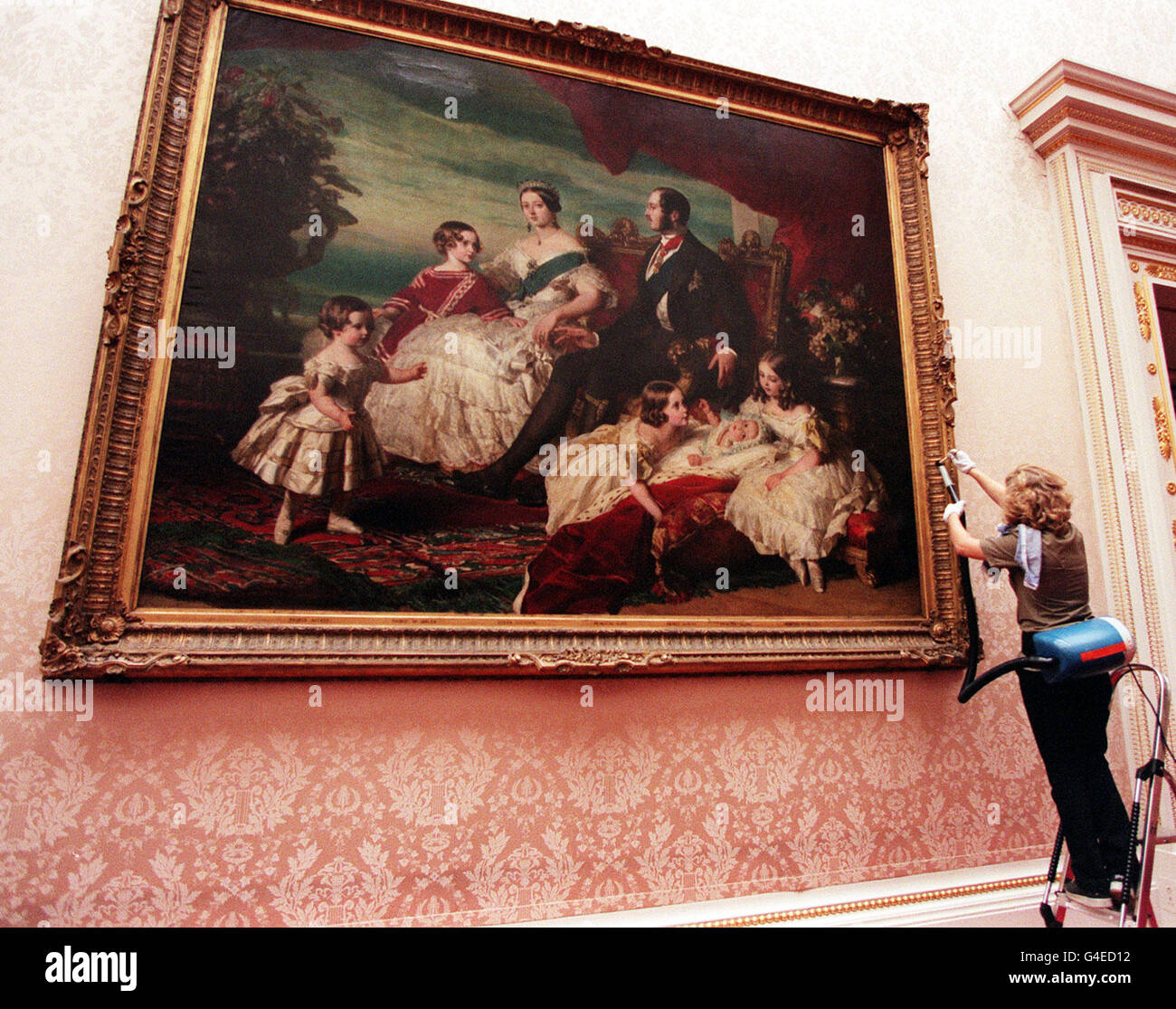 A painting in the East Gallery, Buckingham Palace, of Queen Victoria with Prince Albert and family in 1846 by Fran Winterhalter is cleaned today (Friday) ahead of the doors being opened to the public on August 6. Photo by Sean Dempsey/PA Stock Photo