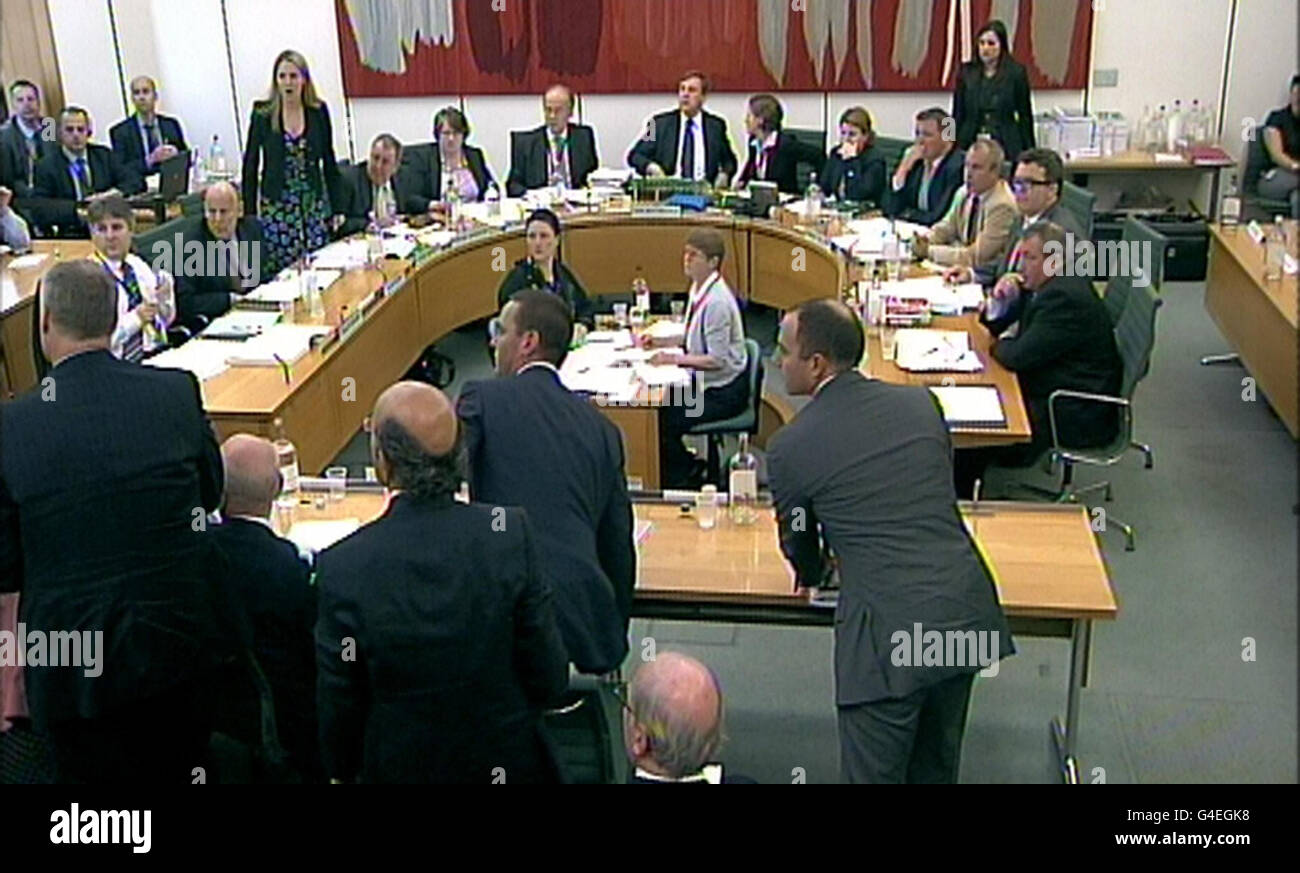 Committee members react after a protestor disrupted proceedings as James Murdoch (left), Deputy Chief Operating Officer and Chairman and Chief Executive Officer, International News Corporation and Rupert Murdoch, Chairman and Chief Executive Officer, News Corporation gave evidence to the Culture, Media and Sport Select Committee in the House of Commons in central London on the News of the World phone-hacking scandal. Stock Photo