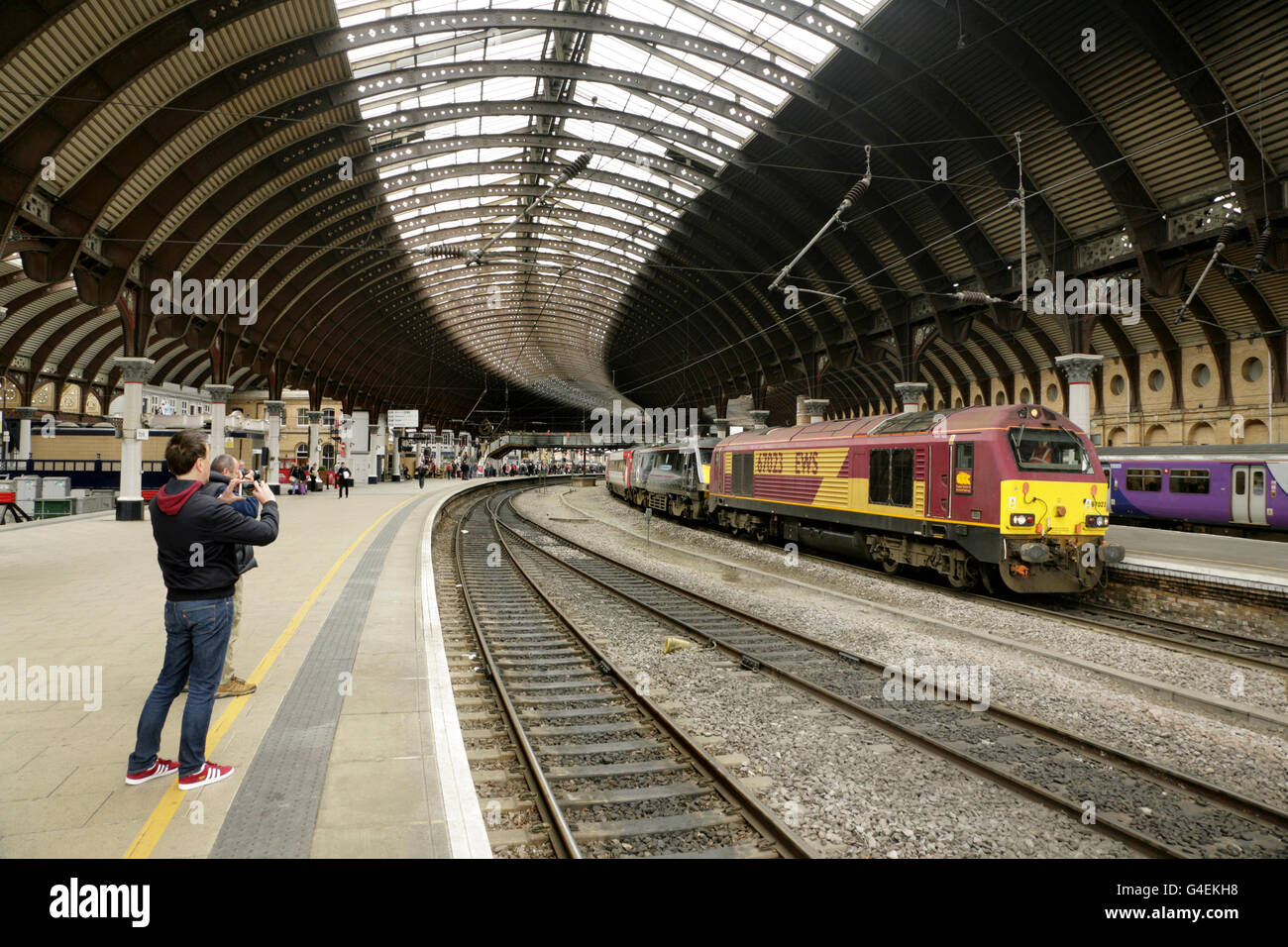 Rail enthusiast photographing EWS class 67 loco 67023 at York station, UK. Stock Photo