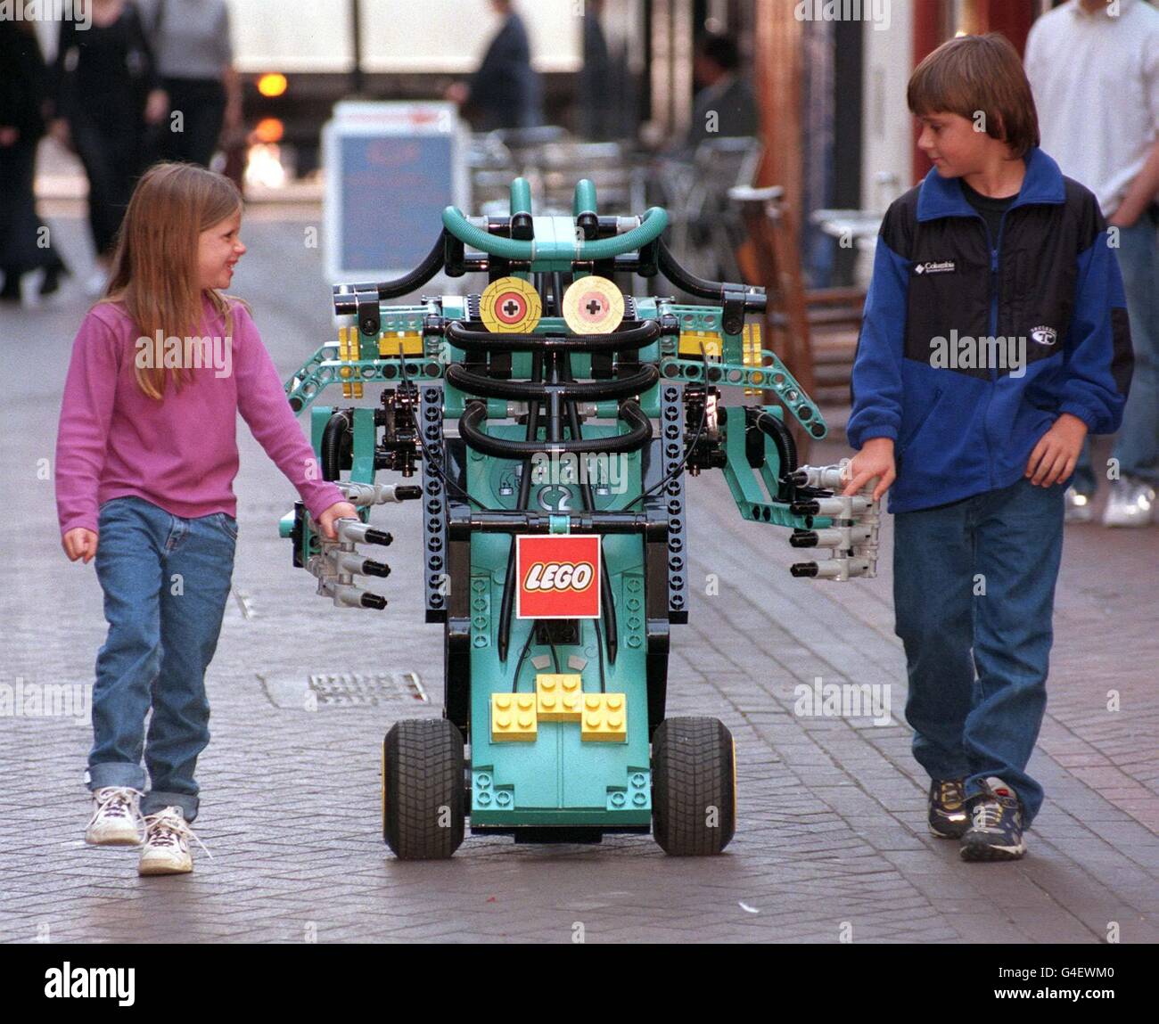 Crusher, from Lego's Cybermaster range walks down London's Regent Street with Torrie Moss, aged 7 and her brother Trevor 12, from Denver Colorado, this morning (Wednesday) during a photocall