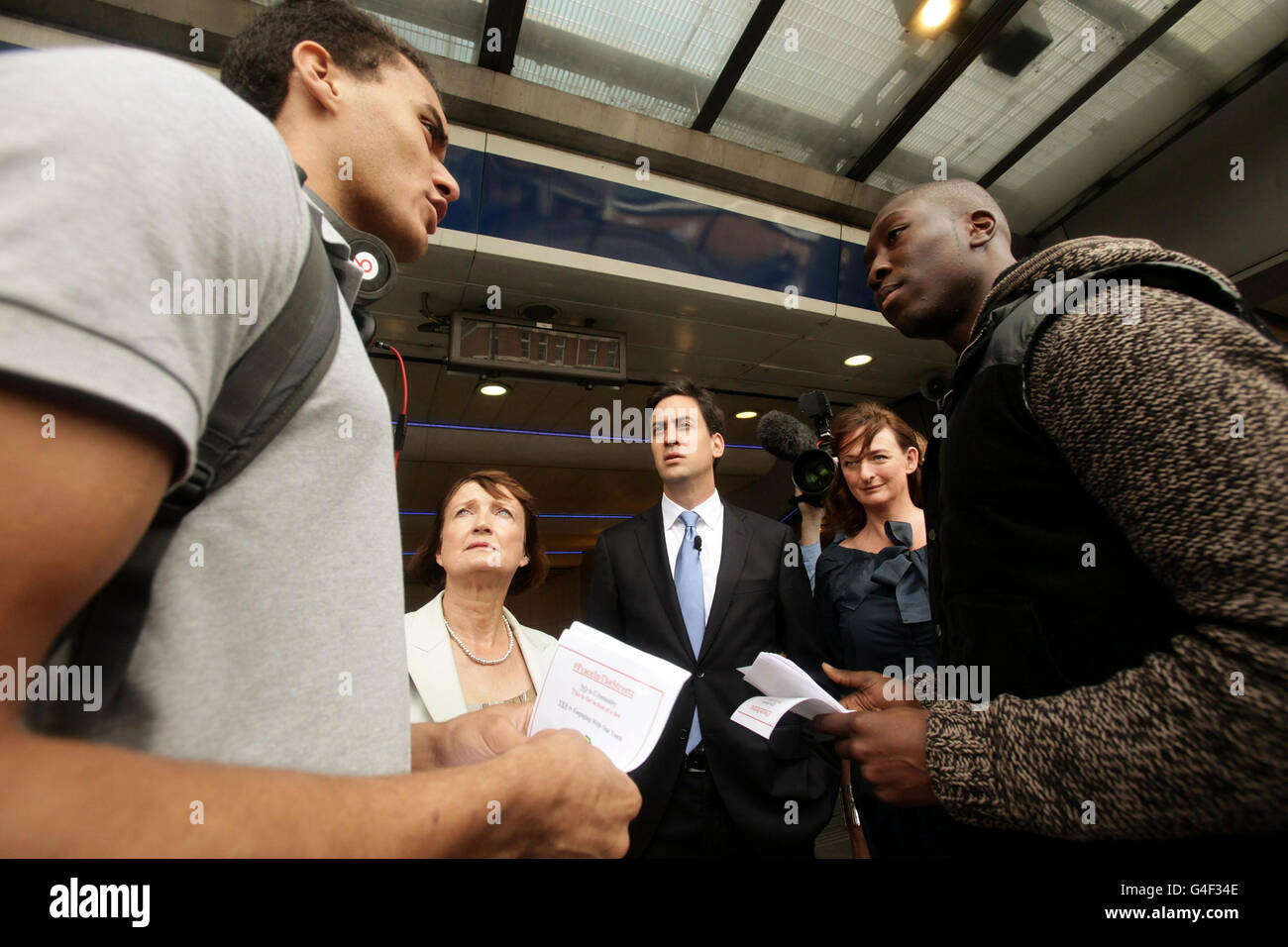 Labour leader Ed Miliband (centre), Labour MP Tessa Jowell (centre left) and Cllr Rachel Heywood of Lambeth Borough Council, meet Joshua Price (left) and Lionel Owusu outside Brixton underground station, during a visit to see businesses and people affected by the recent disorder, in south London. Stock Photo