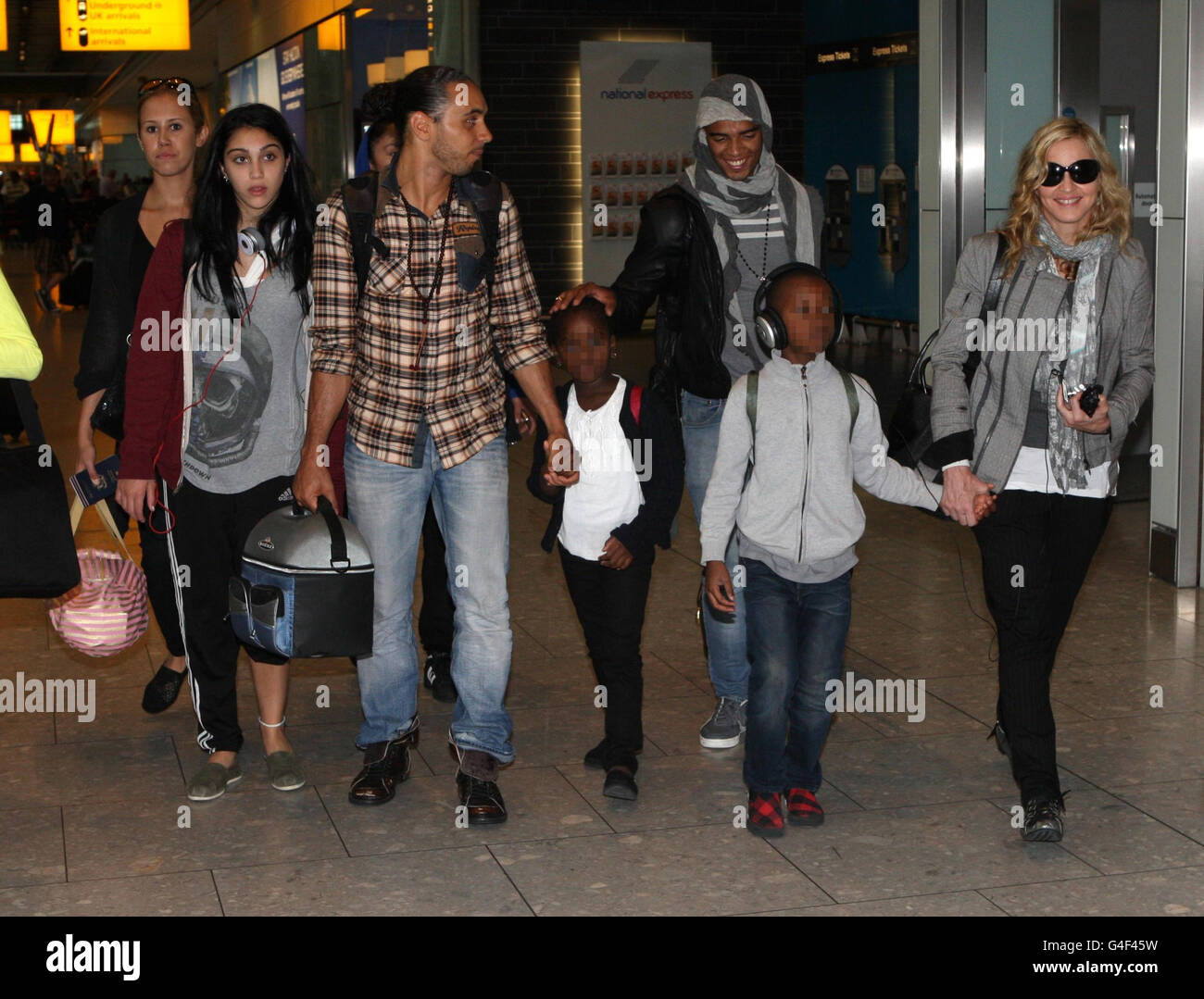 EDITORS NOTE CHILDRENS FACES PIXELATED BY THE PA PICTURE DESK. Madonna (far right) arrives at Heathrow Airport, London, from New York, with her boyfriend Brahim Zaibat (third right) and children Lourdes Leon (second left), David Banda (second right) and Mercy James (centre). Stock Photo