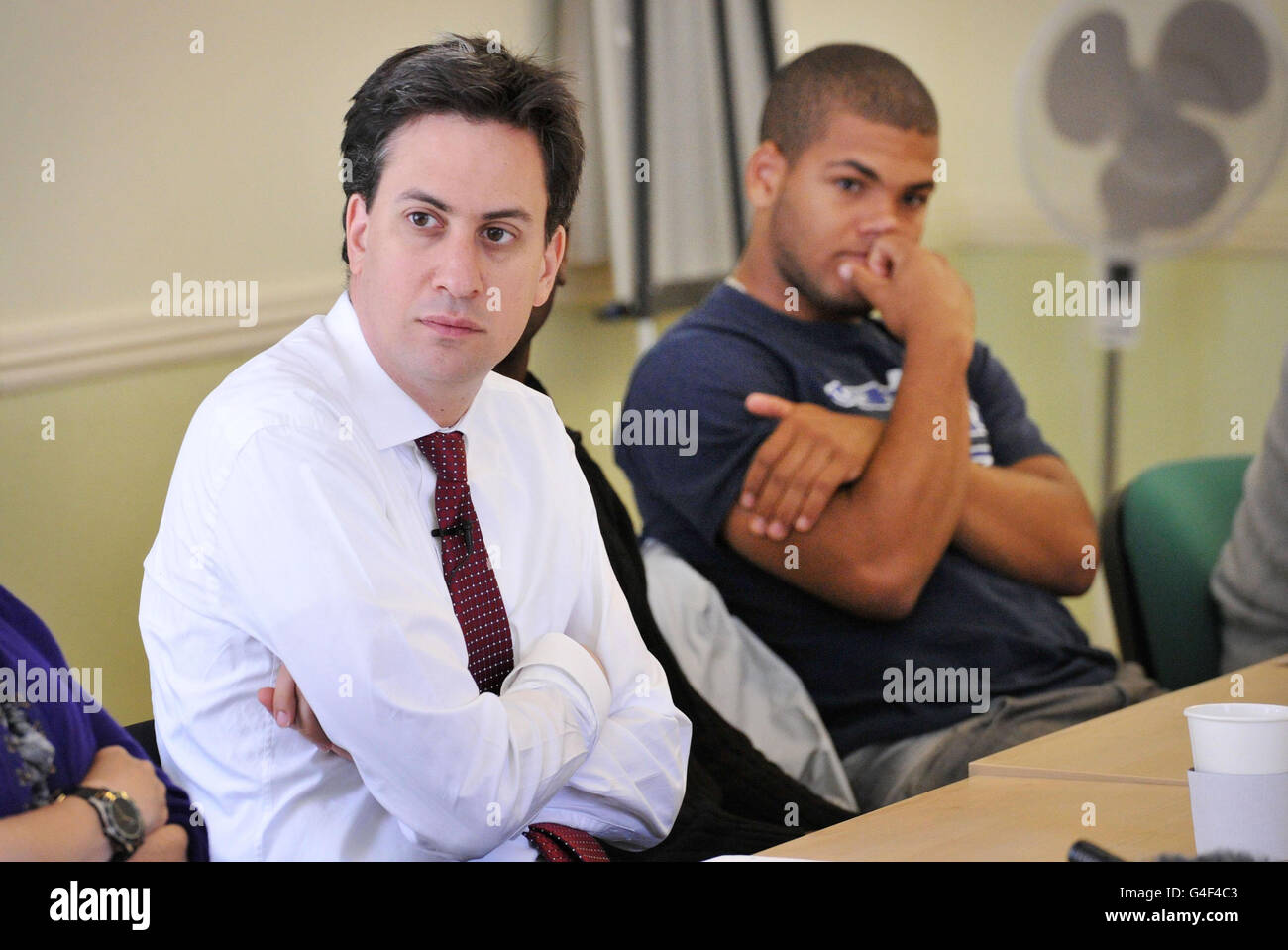 Labour leader Ed Miliband watched by college student Levi Leopard (right) during a meeting in St Pauls in Bristol as part of a visit to the area following last week's disturbances. Stock Photo