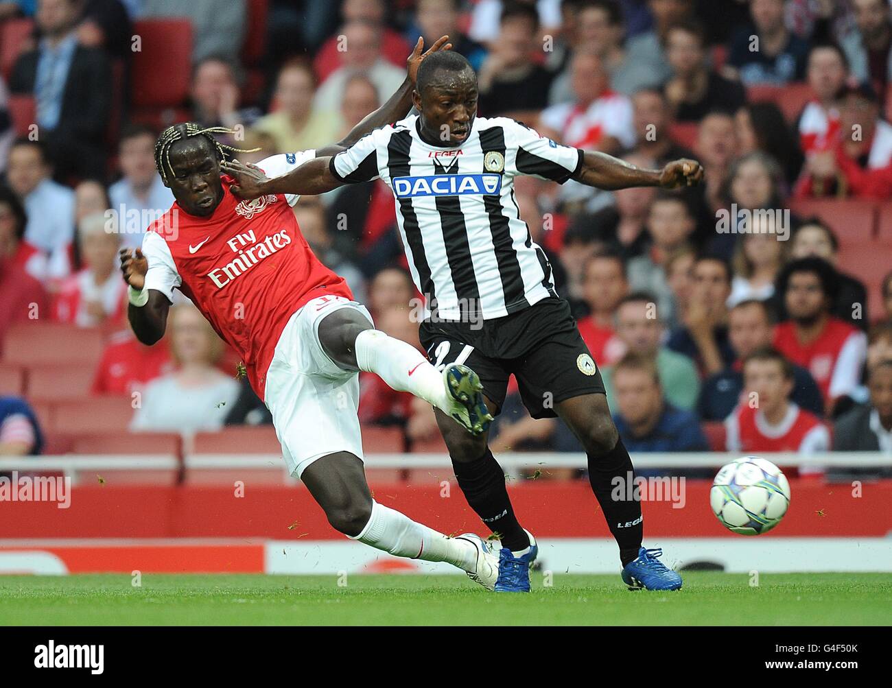 Soccer - UEFA Champions League - Play Offs - First Leg - Arsenal v Udinese - Emirates Stadium. Arsenal's Bacary Sagna (left) and Udinese's Pablo Armero battle for the ball Stock Photo