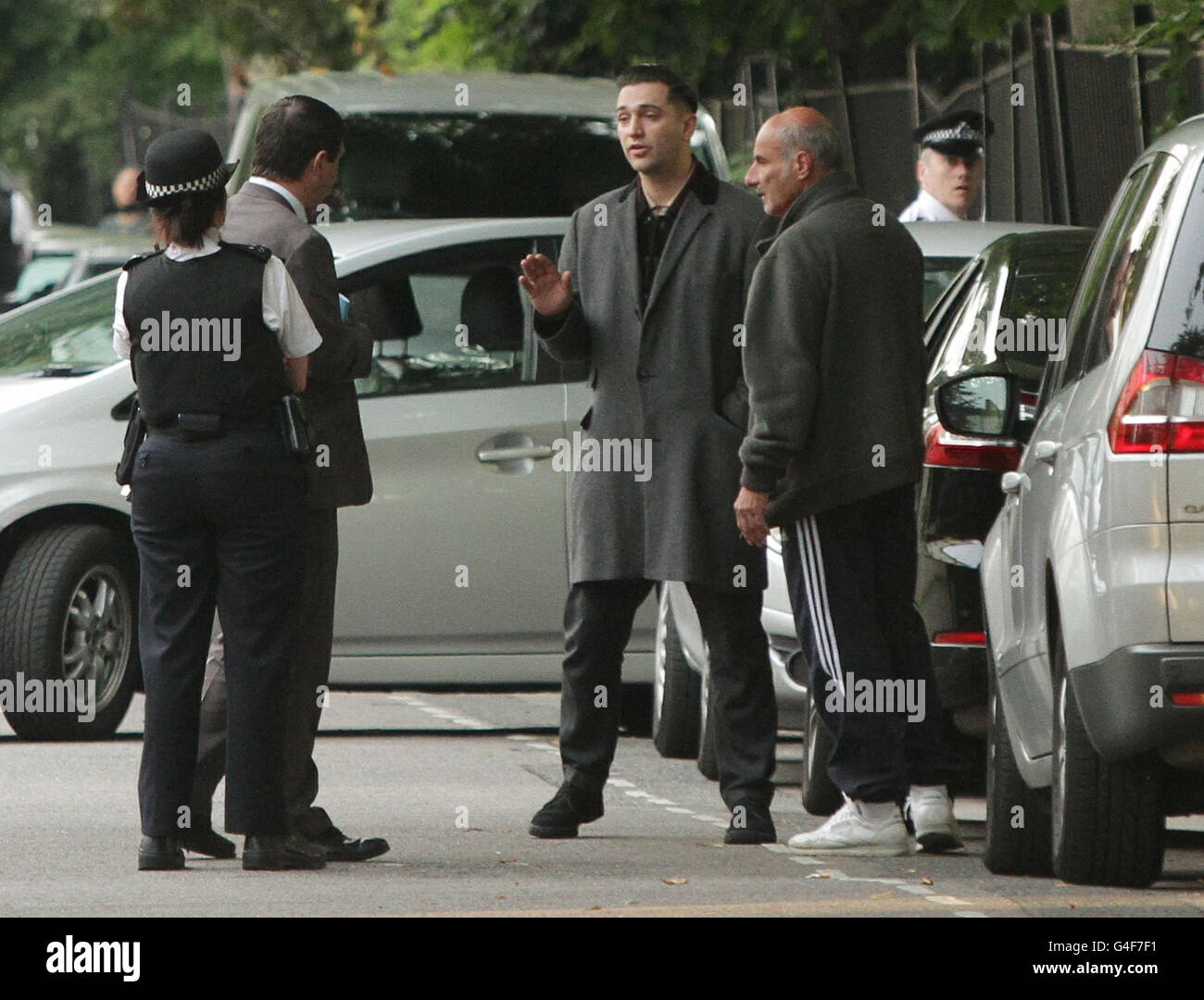 Reg Traviss (centre) talks to police officers at Camden Square in north London, where the singer Amy Winehouse was found dead in her home. Stock Photo