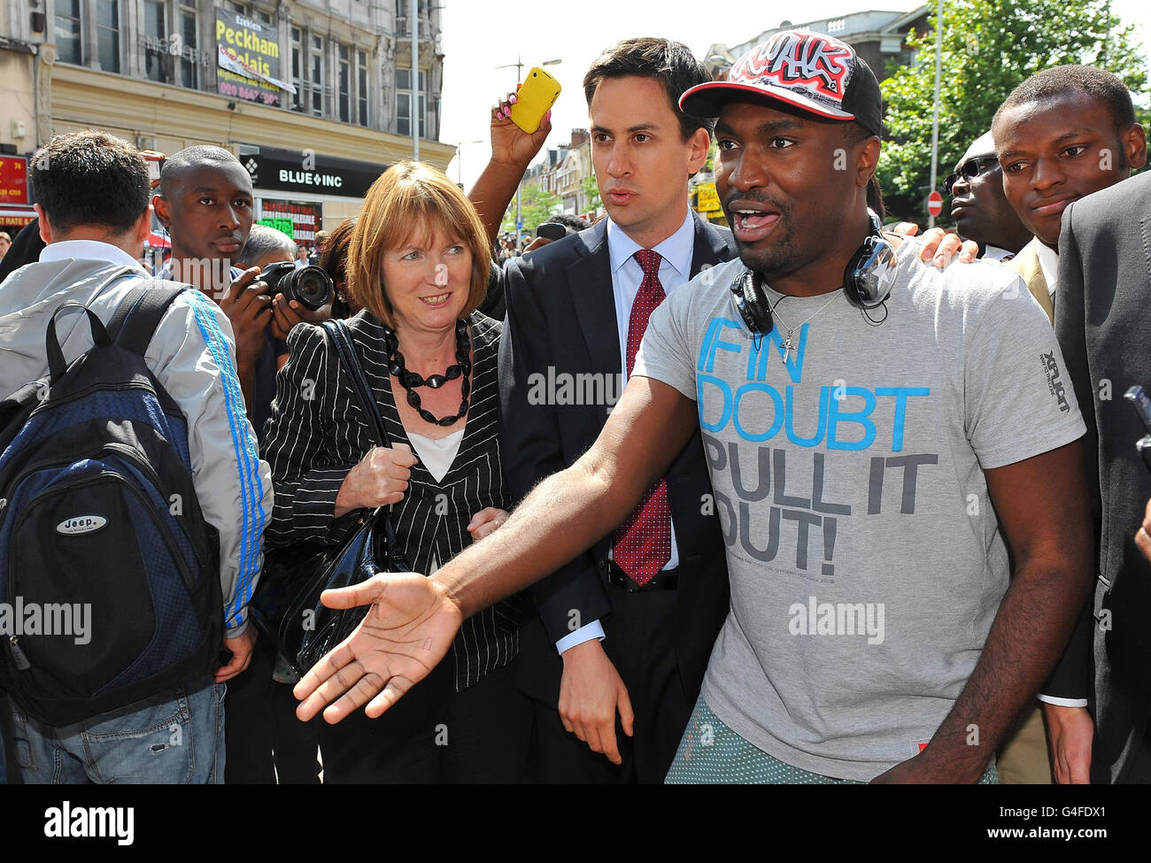 Labour leader Ed Miliband (centre) and Deputy Leader of the Labour Party Harriet Harman speak with Stafford Blake (right) during a visit to Peckham in south London, where rioting took place last night. Stock Photo