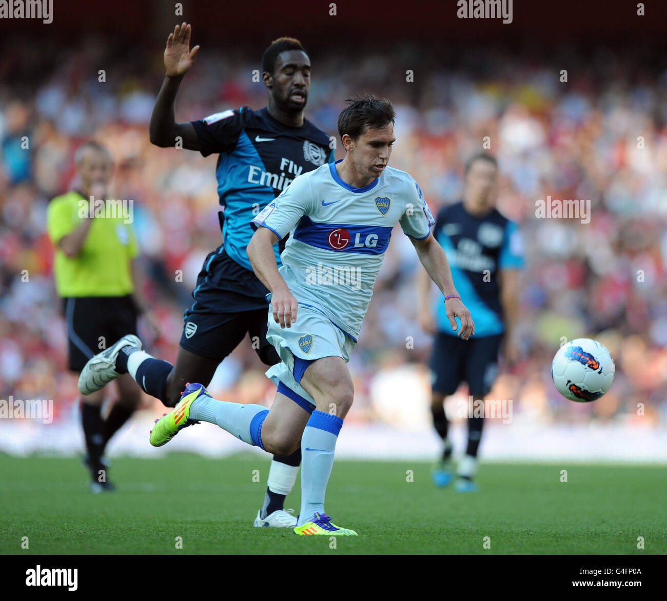 Arsenal's Johan Djourou (left) and Boca Juniors Pablo Mouche battle for the ball during the Emirates Cup match at the Emirates Stadium, London. Stock Photo
