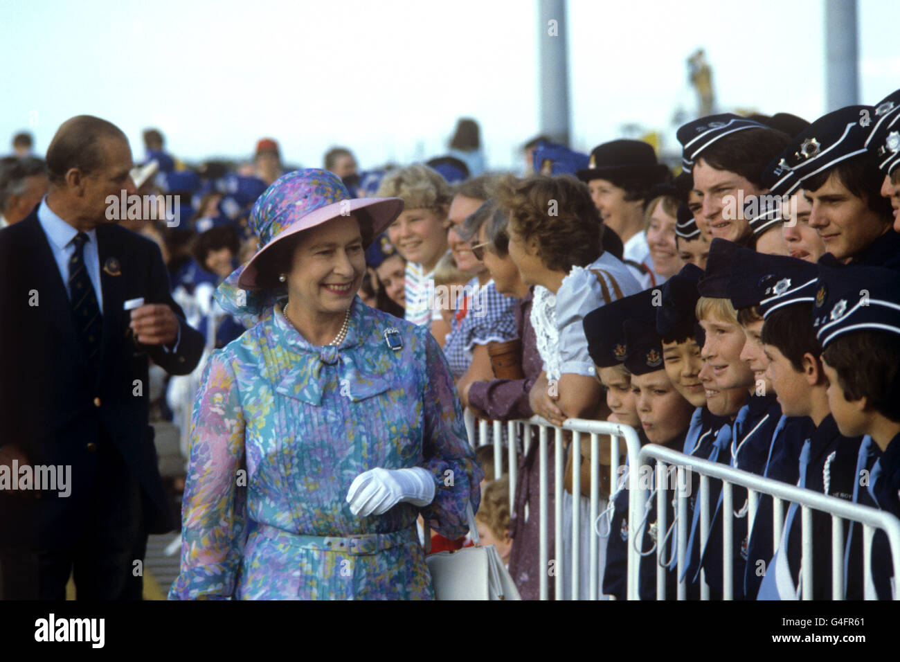 Queen Elizabeth II stops to greet young people as she arrives at Brisbane's Chandler Sports Complex to watch swimming events during the Commonwealth Games. Stock Photo