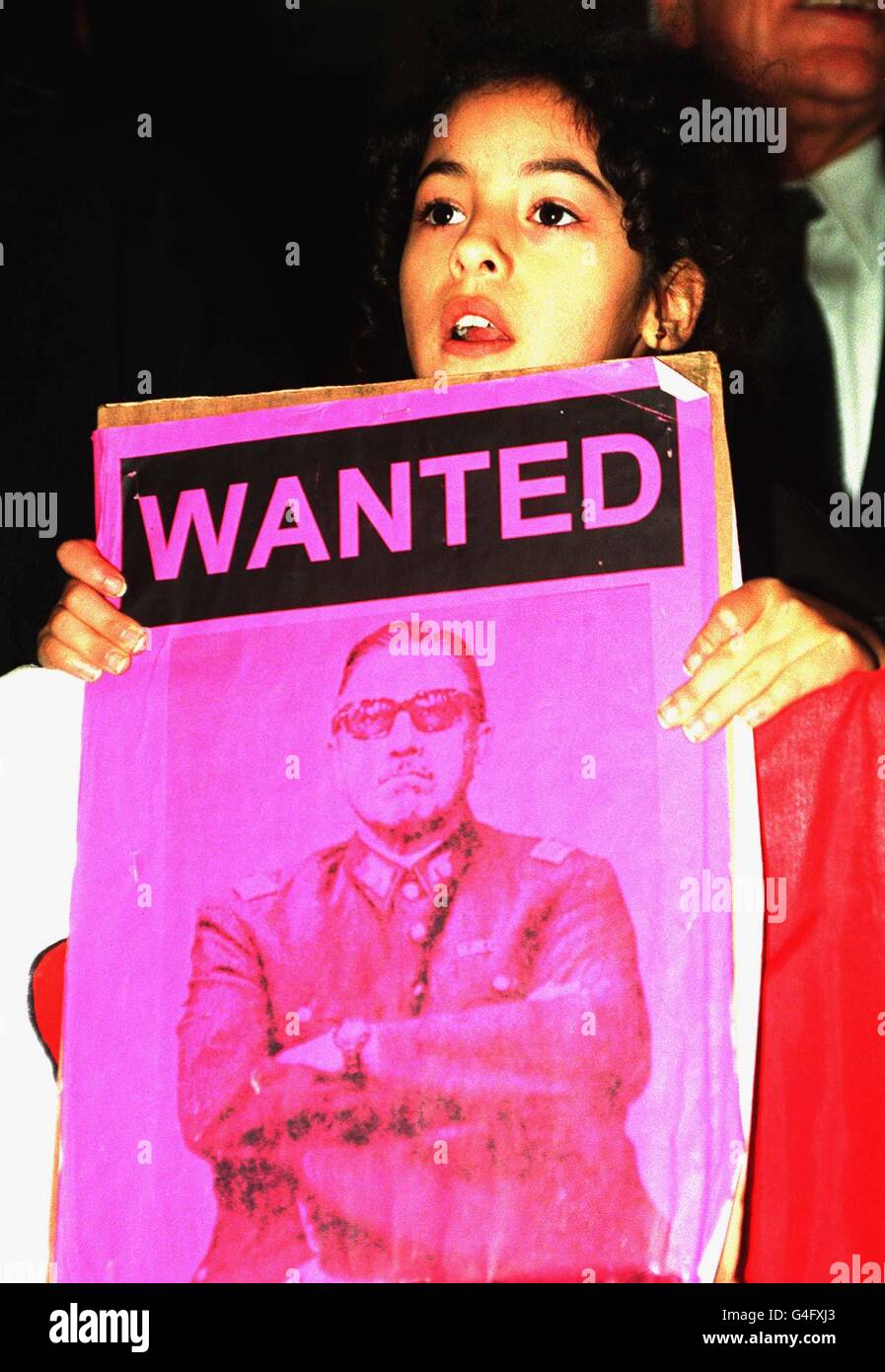 A young girl stands holding a poster outside the west London clinic where 82-year-old General Augusto Pinochet is under arrest and recuperating from back surgery.The former Chilean dictator was arrested last week on a provisional warrant which accused him of murdering Spanish citizens in Chile between 1973 and 1983. See PA story POLICE Pinochet. Photo by Neil Munns/PA Stock Photo