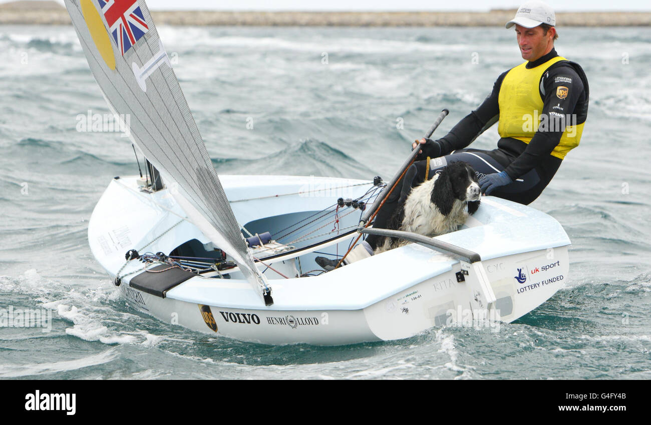 British Olympic hopeful Ben Ainslie celebrates winning the medal race in the Finn class with his friend's dog, Kim, during the London Olympic Games 2012 Test event and International Regatta in Weymouth. Stock Photo
