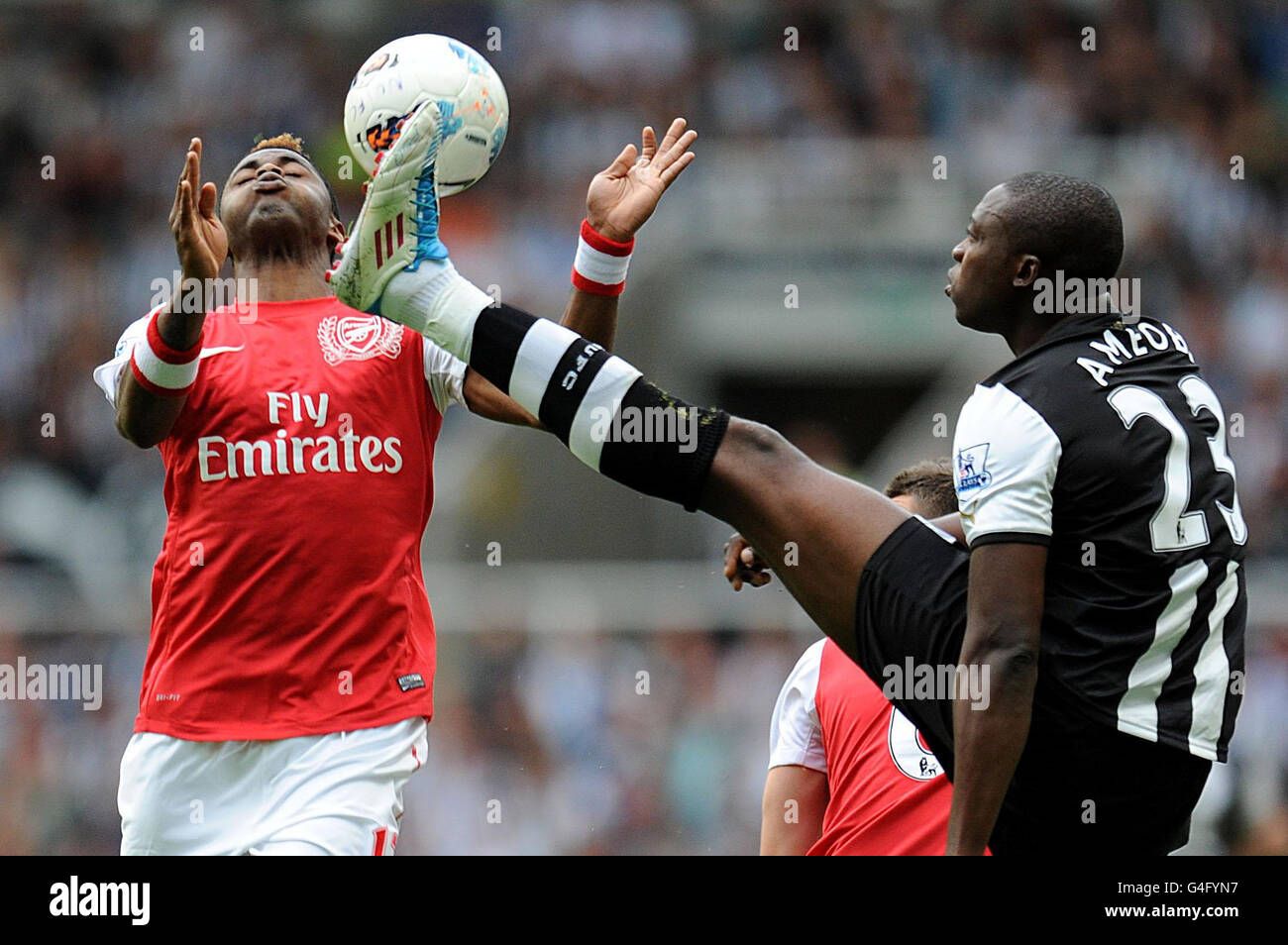 Arsenal's Alex Song (left) and Newcastle United's Shola Ameobi (right) battle for the ball during the Barclays Premier League match at St James' Park, Newcastle. Stock Photo