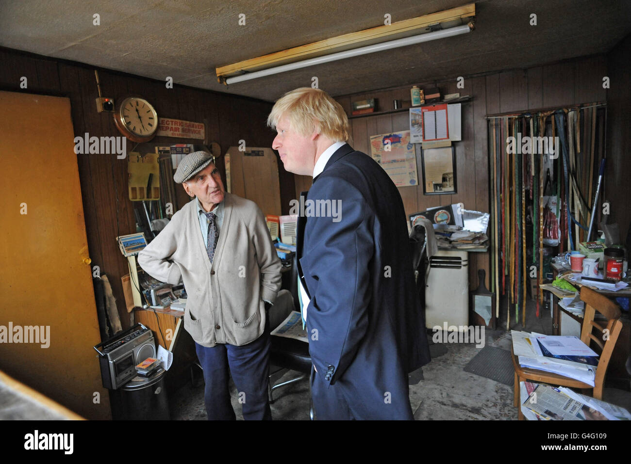 London Mayor Boris Johnson meets 89 year old barber Aaron Biber whose barber shop was ransacked during disturbances in Tottenham on August 6th. So far local people have raised 35000 to get Mr Biber back in business. Stock Photo