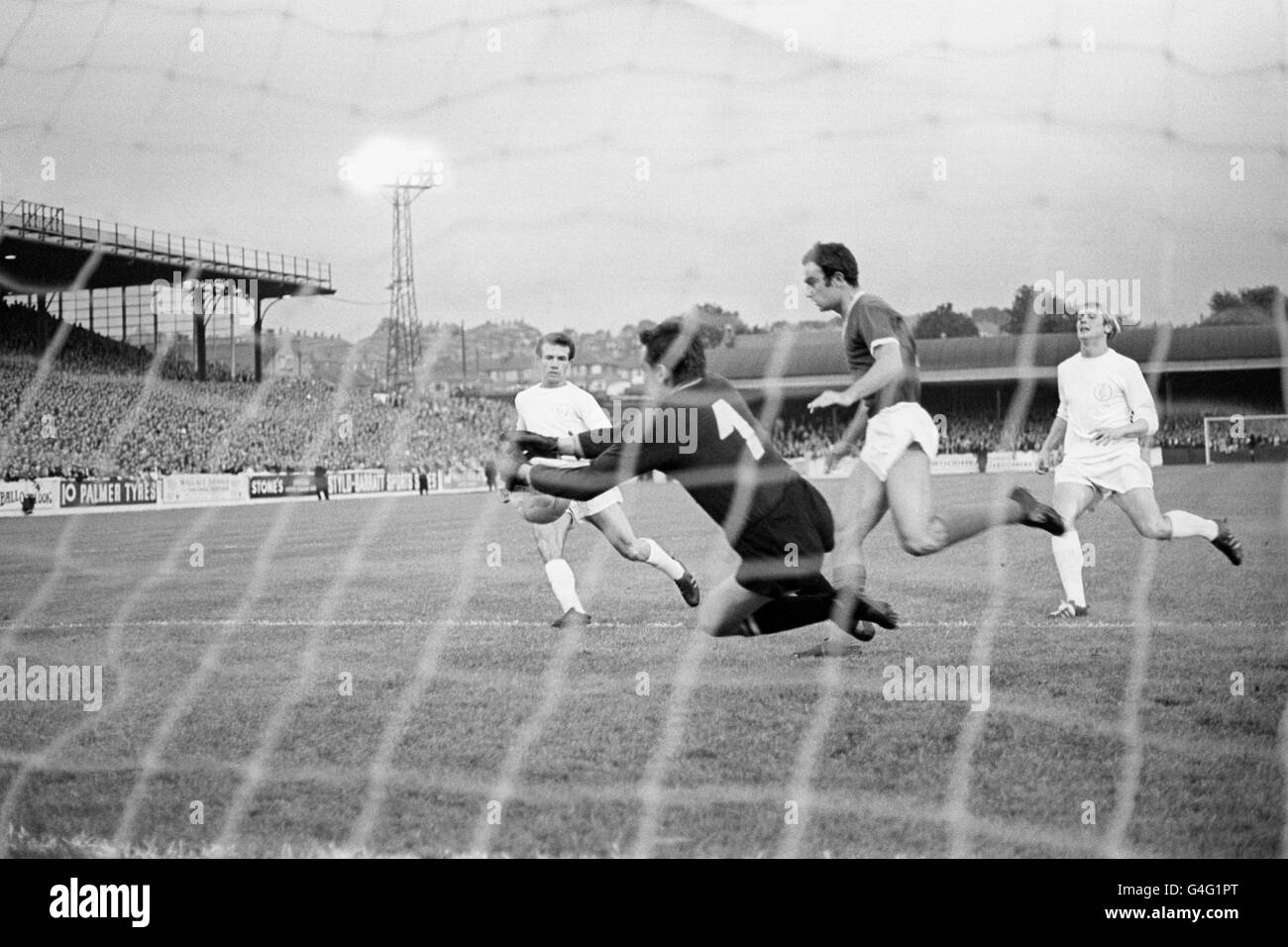 Dinamo Zagreb goalkeeper Zlatko Skoric gets down to make a save. Running in on goal for Leeds United are Paul Reaney (l) and Jimmy Greenhoff (r). Stock Photo