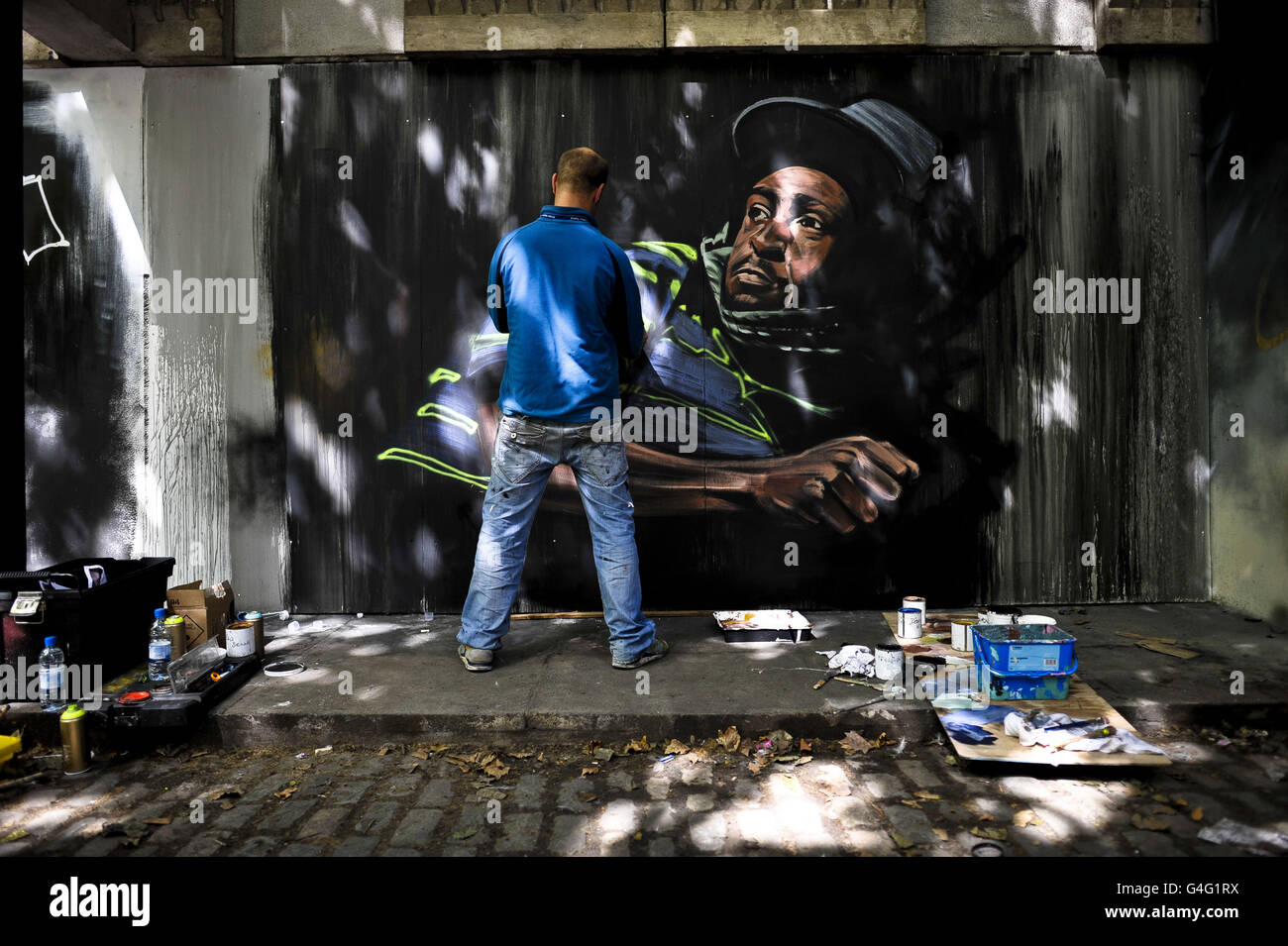 Artist cosmo paints piece of street art on nelson street hi-res stock