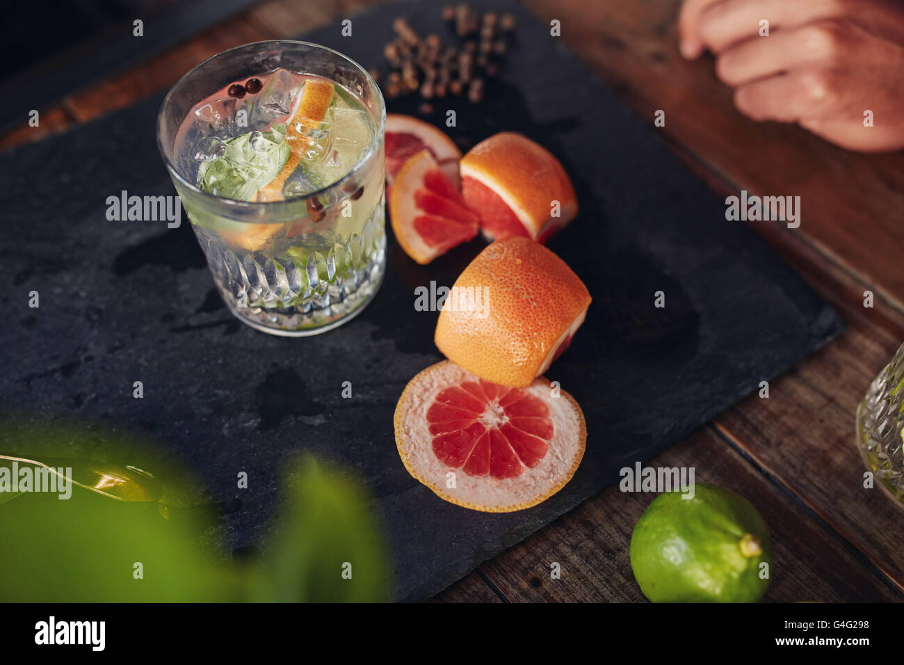 Close up image of freshly prepared cocktail drink with grapefruit slices on table. Stock Photo