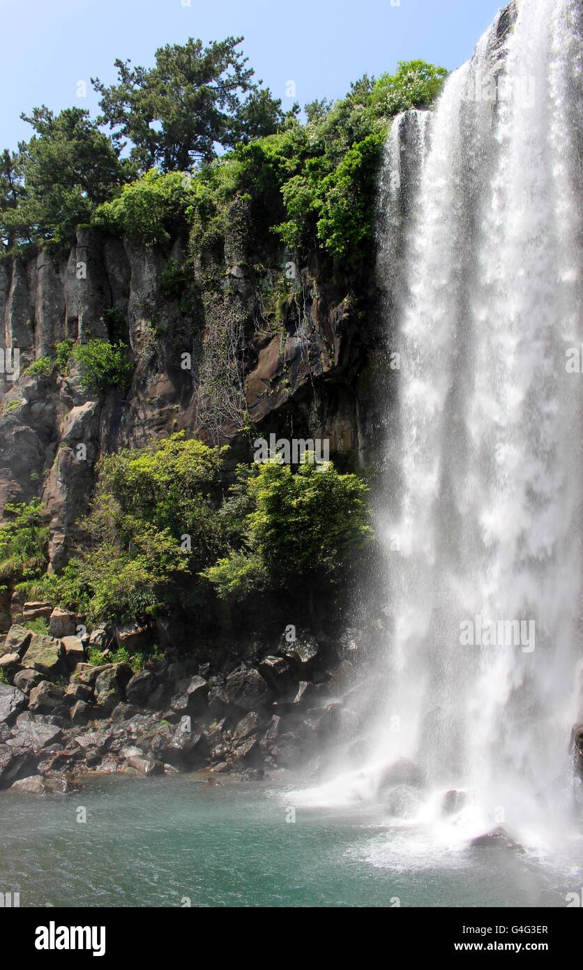 Jeju Island's Jeongbang Falls is the only waterfall in Asia to fall directly into the ocean. Stock Photo