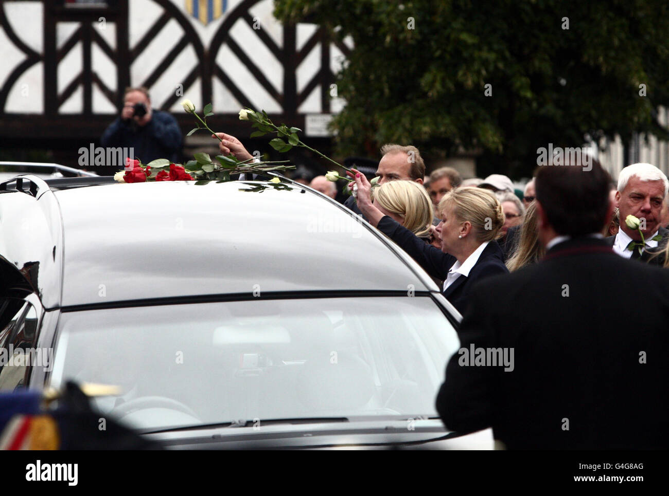 Friends and family places flowers on top of the hearse carrying the coffin of Lieutenant Daniel Clack it passes through Wootton Bassett, Wiltshire, following his Repatriation. Stock Photo