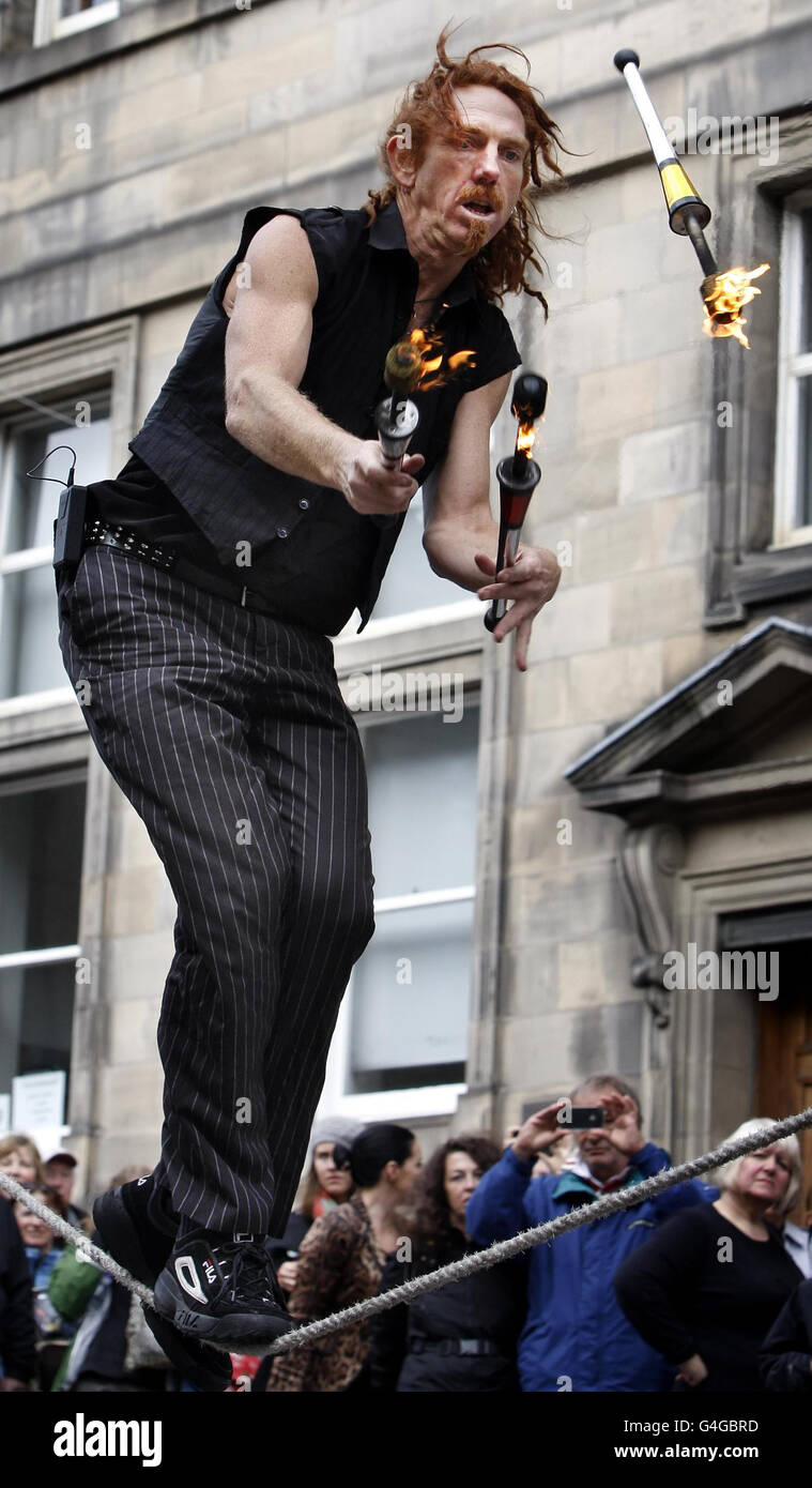 Street artist Deadly Serious perform on Edinburgh's Royal Mile on the last day of the Edinburgh Fringe Festival. Stock Photo