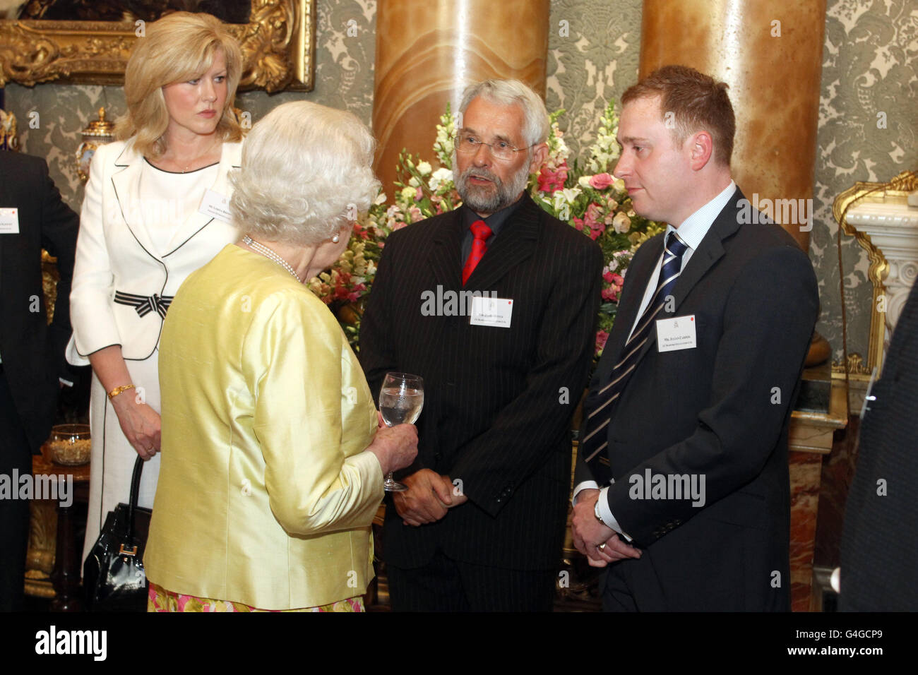 Britain's Queen Elizabeth II meets David Hoyle and Julian Carder (right) of J C Bamford Excavators at a reception for winners of the Queen's Award for Enterprise at Buckingham Palace in London. Stock Photo