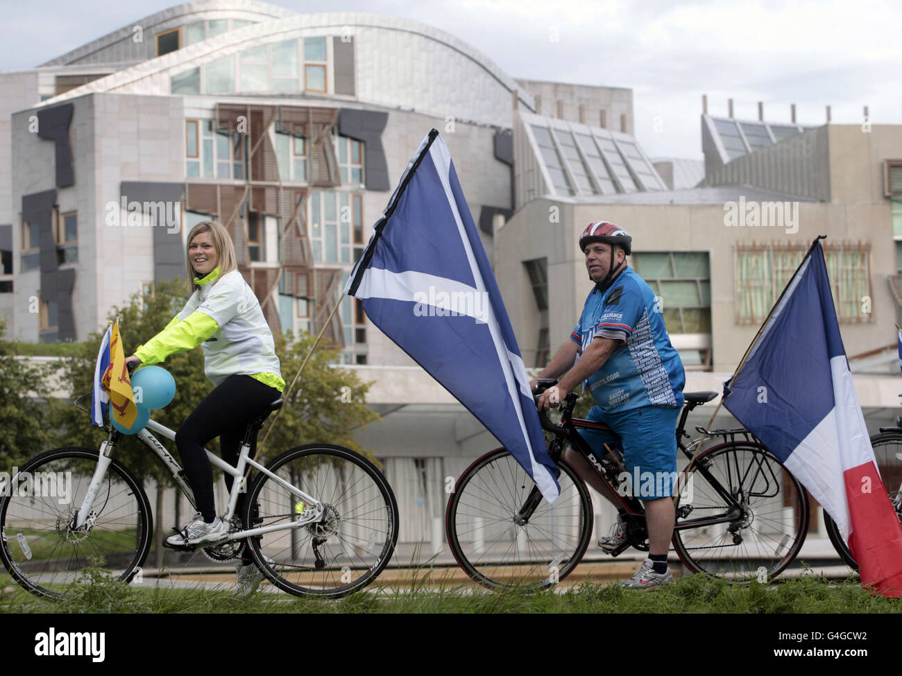 Natalie Hoy and Martin Burnett join a group of cyclists departing on a fund-raising journey to Paris as they set off from the Scottish parliament in Edinburgh. Stock Photo