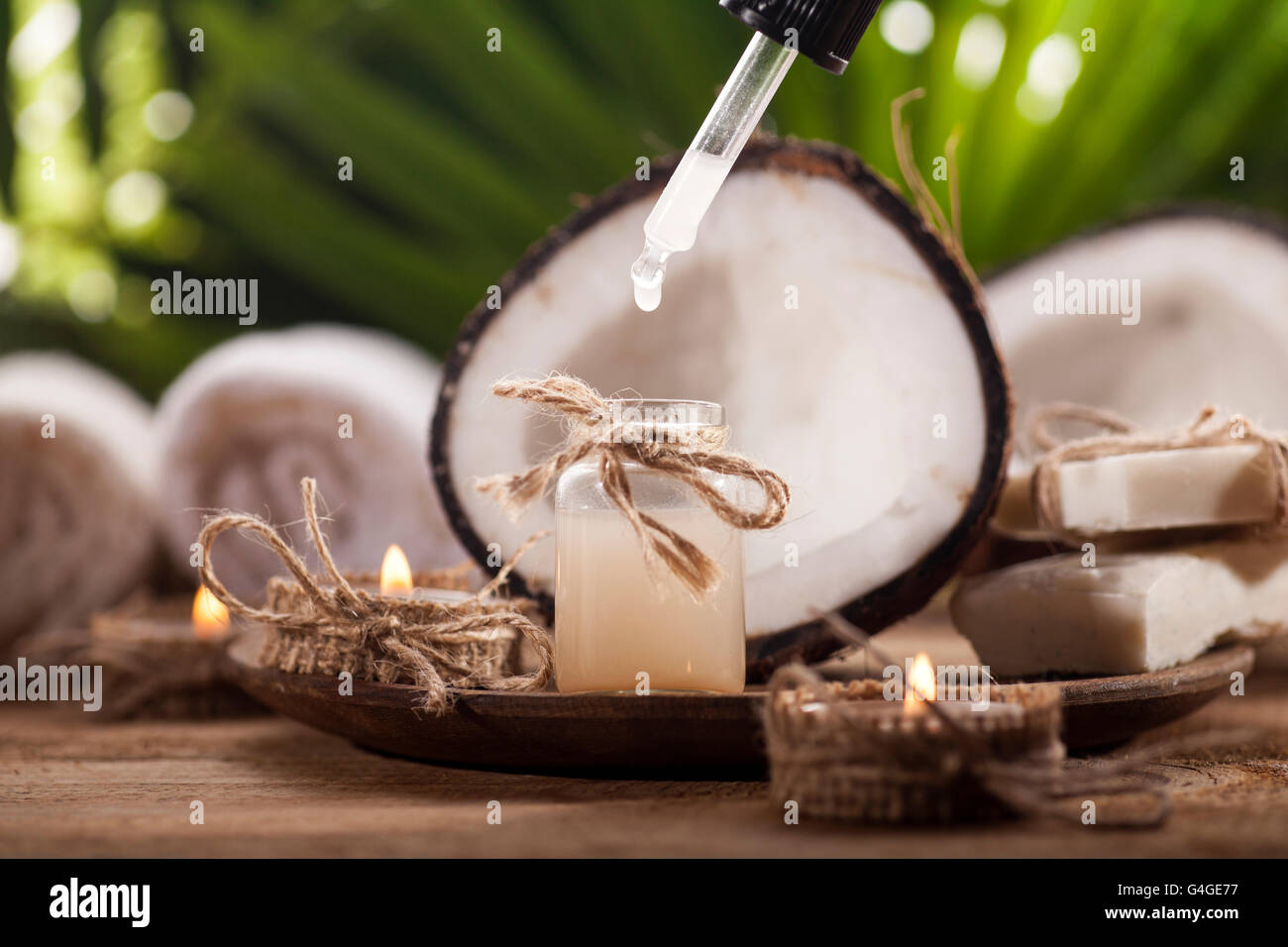 Coconuts and coconut oil on wooden table, on nature background. Health