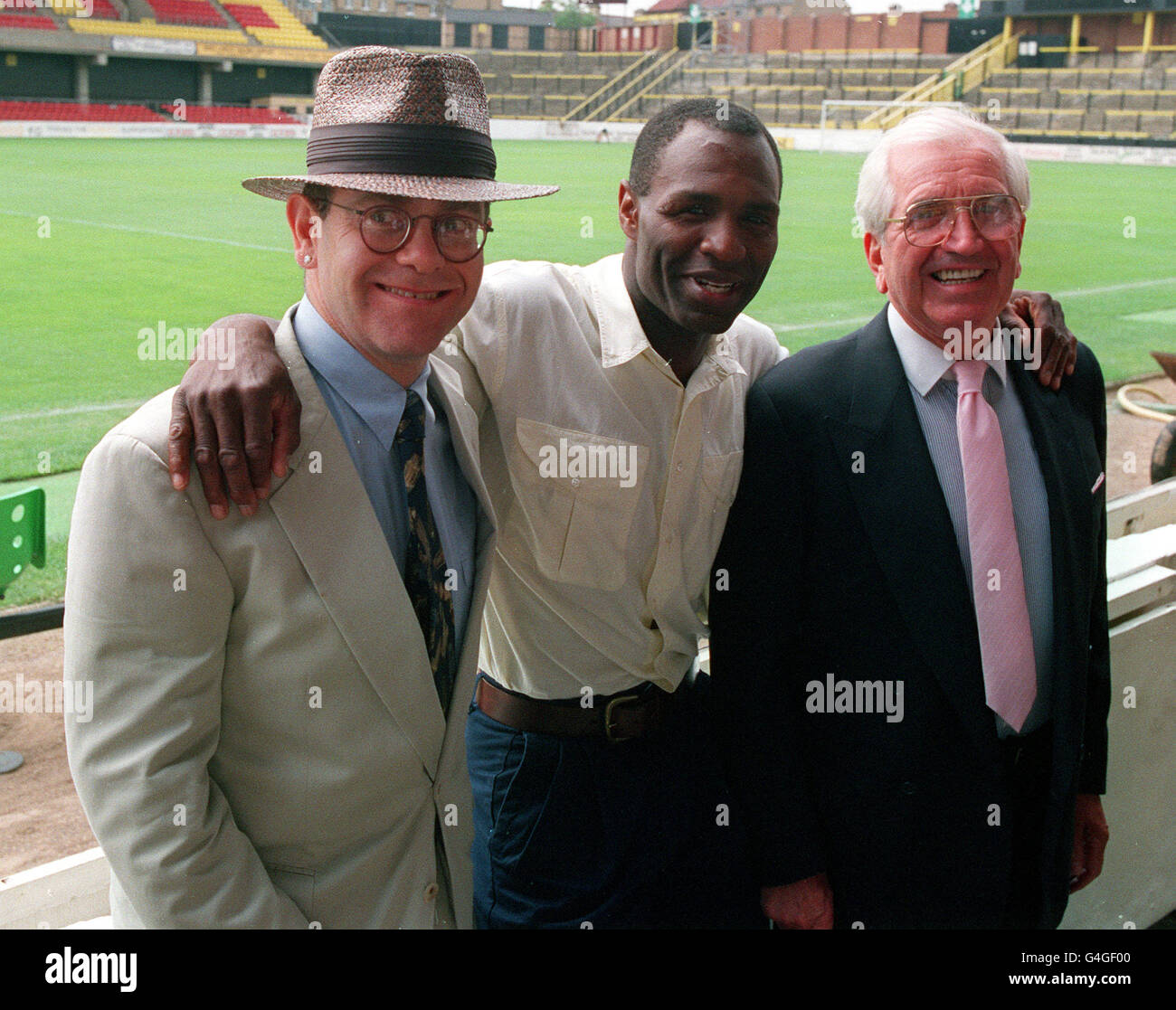 PA NEWS PHOTO 5/8/91  ELTON JOHN (DIRECTOR) WITH NEW SIGNING LUTHER BLISSETT AND CHAIRMAN JACK PETCHIE (RIGHT) DURING A PHOTOCALL AT WATFORD F.C. GROUND, VICARAGE ROAD Stock Photo