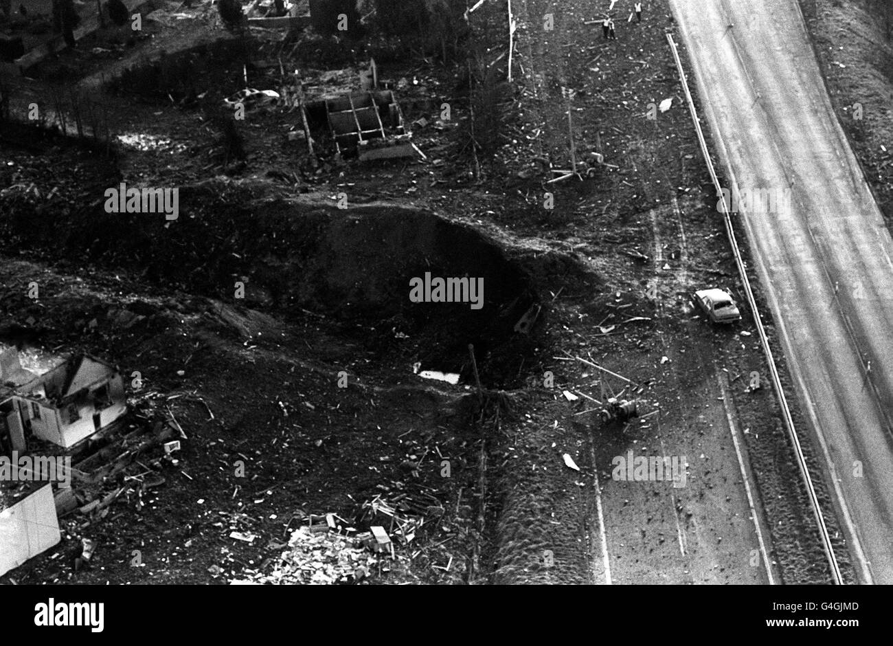 PA NEWS PHOTO 22/12/88 AN AERIAL VIEW SHOWING THE MASSIVE CRATER NEXT TO THE A74 MAIN ROAD AND HOUSES DEVASTATED BY THE PAN AM BOEING 747 JUMBO JET WHICH CRASHED INTO THE SCOTTISH TOWN OF LOCKERBIE, NEAR DUMFRIES, SCOTLAND * 30/01/2001: Three judges will be returning to court 31/01/2001 in Camp Zeist in Holland to announce the fate of the two Libyans accused of planting the bomb that destroyed the plane. *140803* A 1.7 million deal to compensate the families of 270 victims killed in the bombing has been agreed by Libya at the end of an exhaustive round of talks with British and American Stock Photo