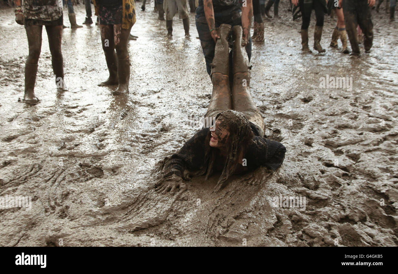 Festival goer Katherine Vincent is dragged around in the mud during the
