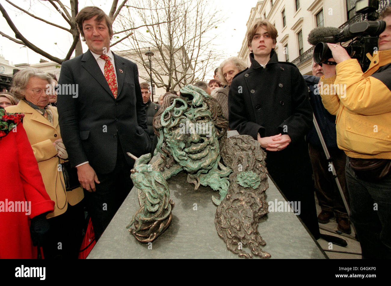Actor Stephen Fry (left) and Oscar Wilde's great-grandson Lucian Holland with a statue of the Irish writer by Maggi Hambling which he unveiled near London's Trafalgar Square today (Monday). The statue is part of a memorial entitled 'A Conversation with Oscar Wilde' which depicts Wilde in bronze rising from his granite sarcophagus. Fry played the Irish playwright in a recent film. Picture by Peter Jordan. /PJ. 7/12/98 Stock Photo