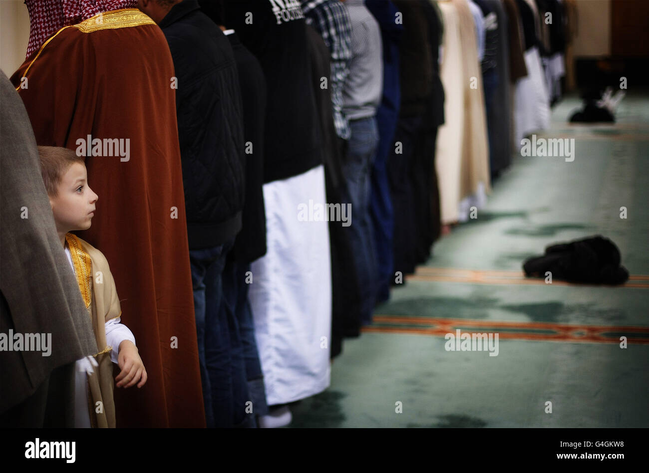 A child looks behind him during noon prayers in Clonskeagh Mosque on the day of Eid which marks the end of the month of Ramadan in the Muslim calendar. Stock Photo