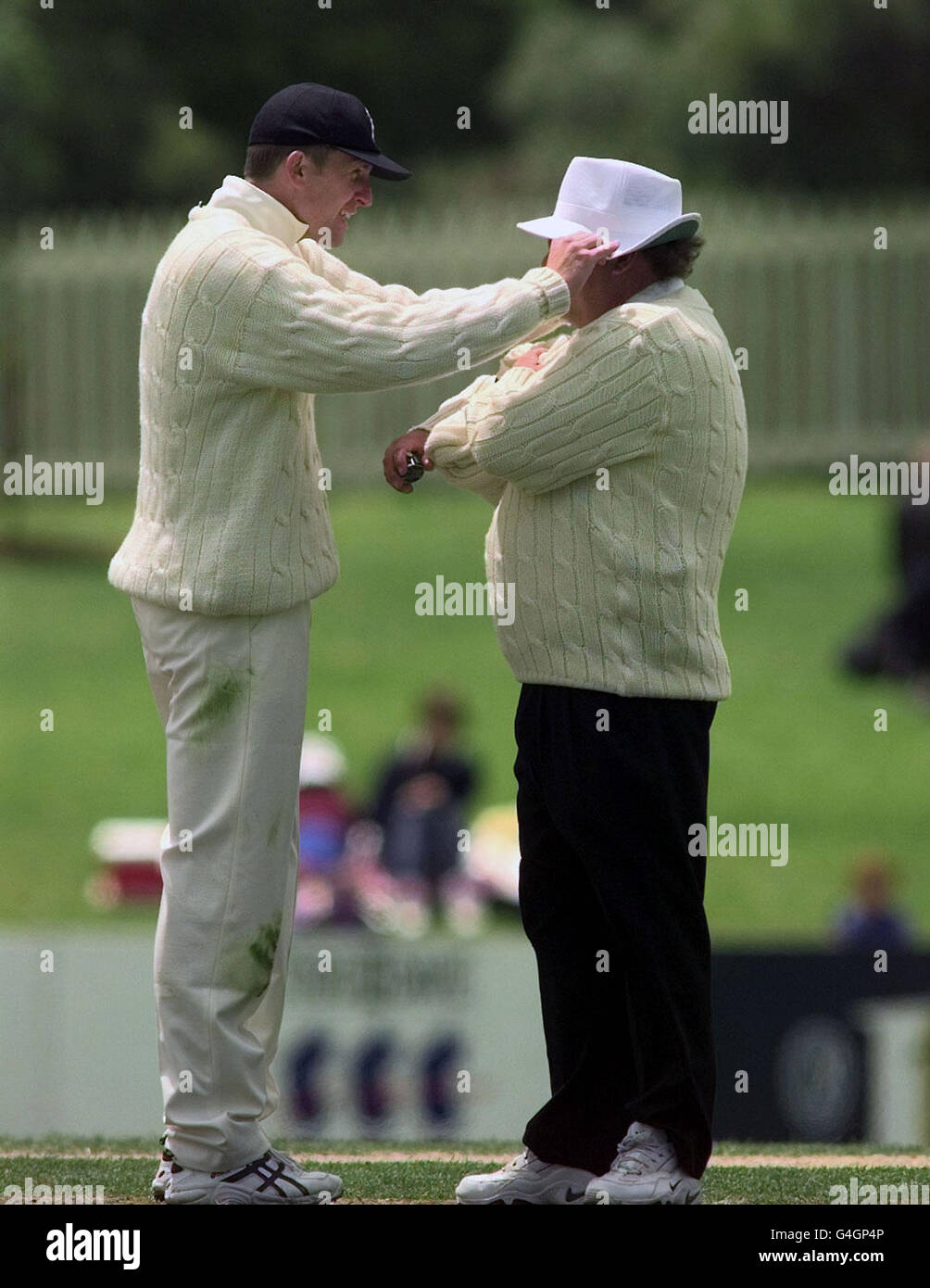 England's Dominic Cork (L) puts the hat back on umpire Peter Parker