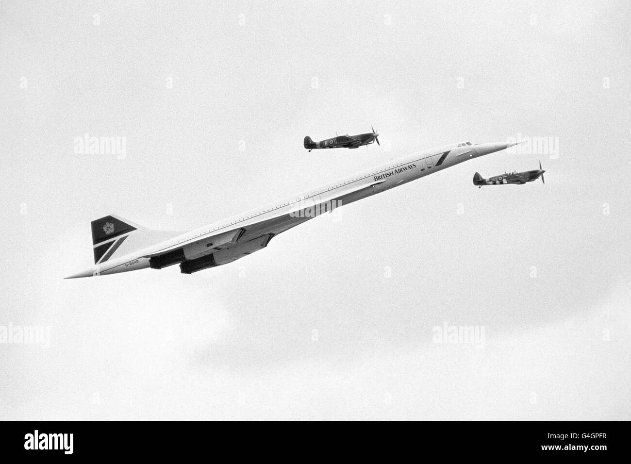 A British Airways Concorde is shadowed by two Second World War Spitfires as it arrives to make a pass over Biggin Hill during the Air Show Stock Photo