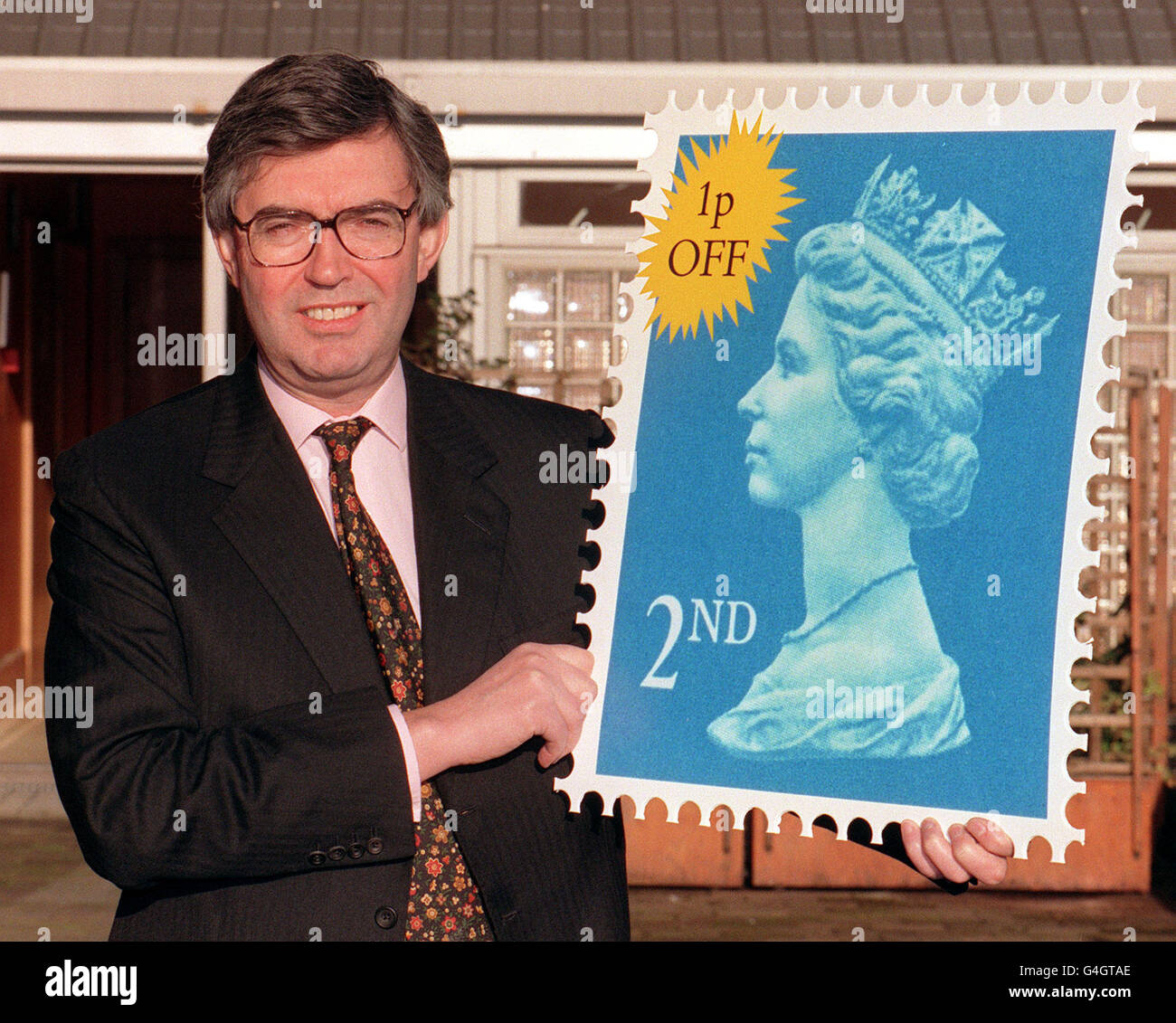Royal Mail managing director, Richard Dykes, holds up a giant 2nd Class Stamp, at the Post Office Headquarters in London after Royal Mail cut the price of second class post by a penny to 19p and vowed to continue the price freeze on the basic first class rate of 26p. Stock Photo
